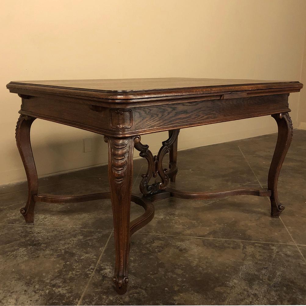 Antique Liegoise draw leaf dining table hails from the storied region from which exceptional products have been hand-crafted for centuries! Utilizing indigenous oak, the artisans crafted a tailored apron supported by boldly scrolled legs carved with