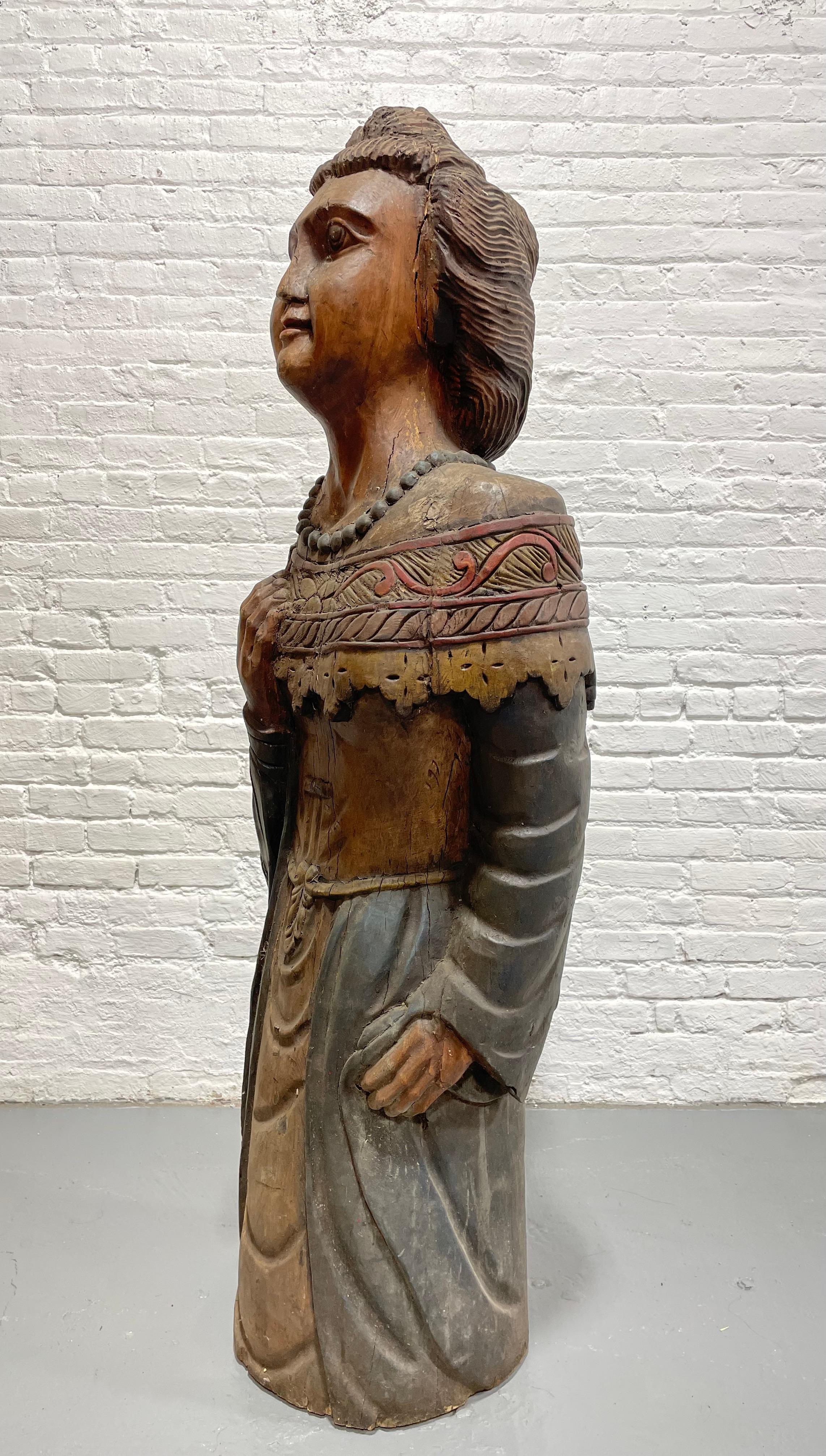 Rare life size hand carved wooden woman figure / statue. Beautifully and intricately hand carved from solid wood. Original painted surface over a thin layer of gesso. Wonderful detailing – pearl necklace, bun hairstyle, and intricate outfit.