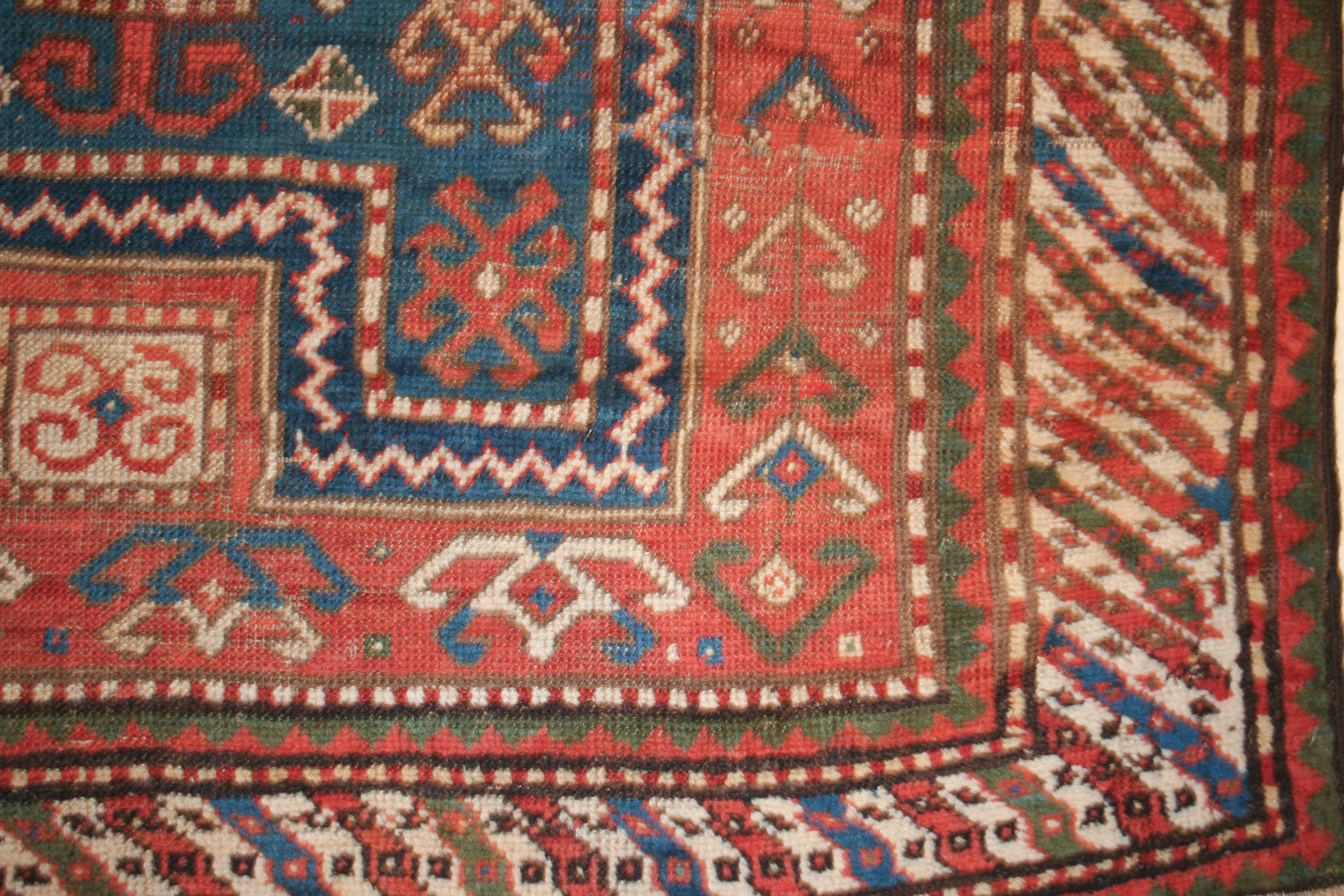 Un exemple très ancien de tapis kazakh, attribué au village de Fachralo dans le sud-ouest du Caucase. Il se caractérise par une réserve centrale bleu clair contenant un médaillon central en diamant ivoire au contour crochu, ponctué de motifs crochus