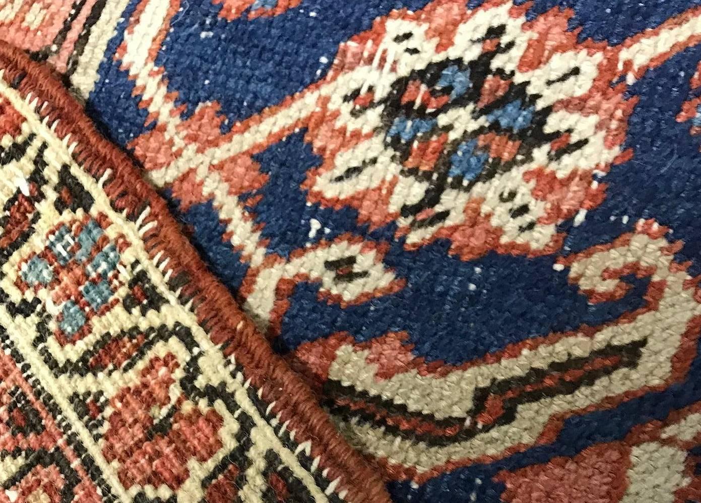 Lightly distressed Persian Serap rug, circa 1900. The general look of this piece is enhanced by the slightly distressed condition of the rug. The rug has a low pile coupled with areas where the warp is showing to add to the overall patina that is so