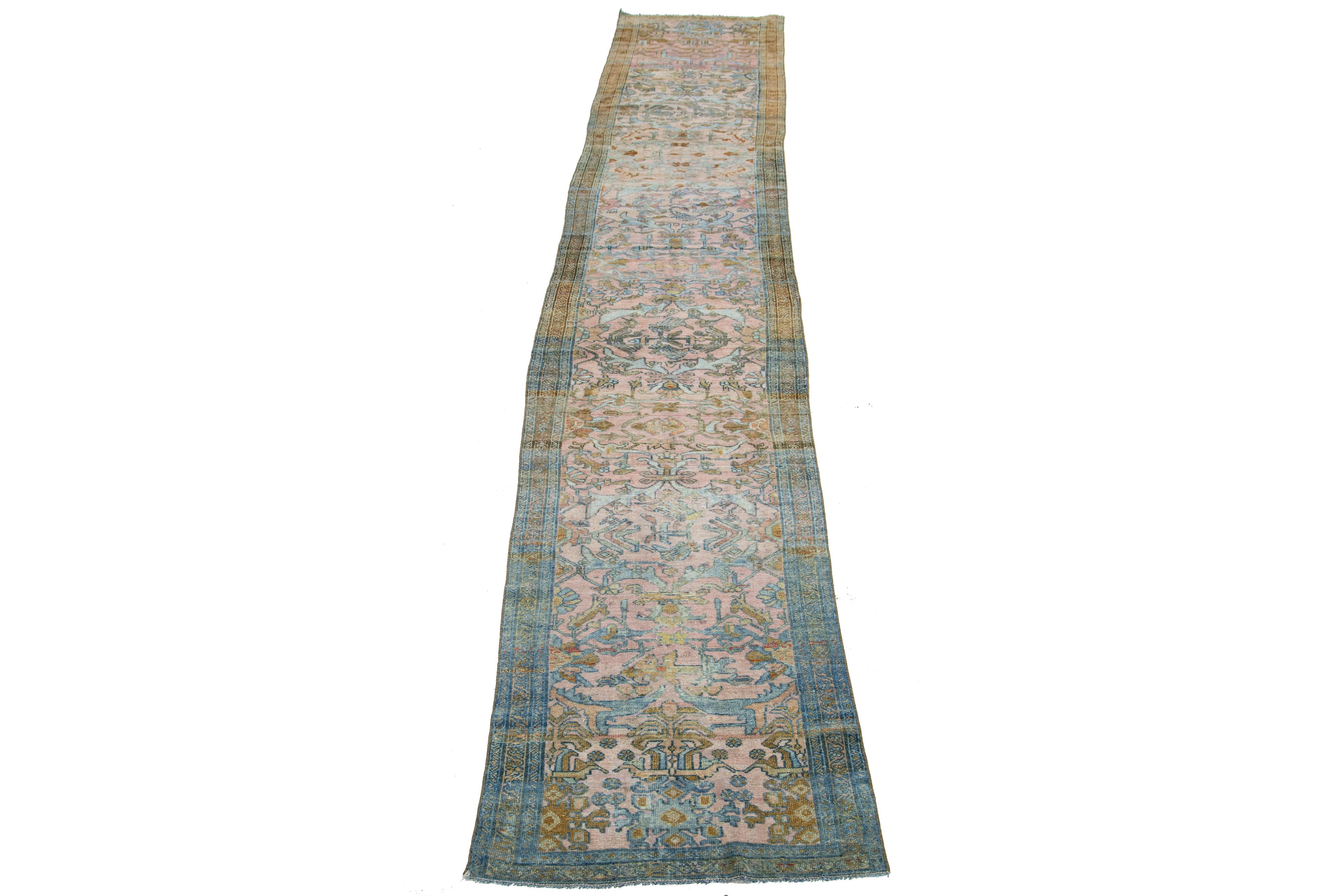 Beautiful antique Lilihan hand-knotted wool runner with a pink field. This Persian has blue borders with an all-over floral pattern design in brown accents. 

This rug measures 2'6