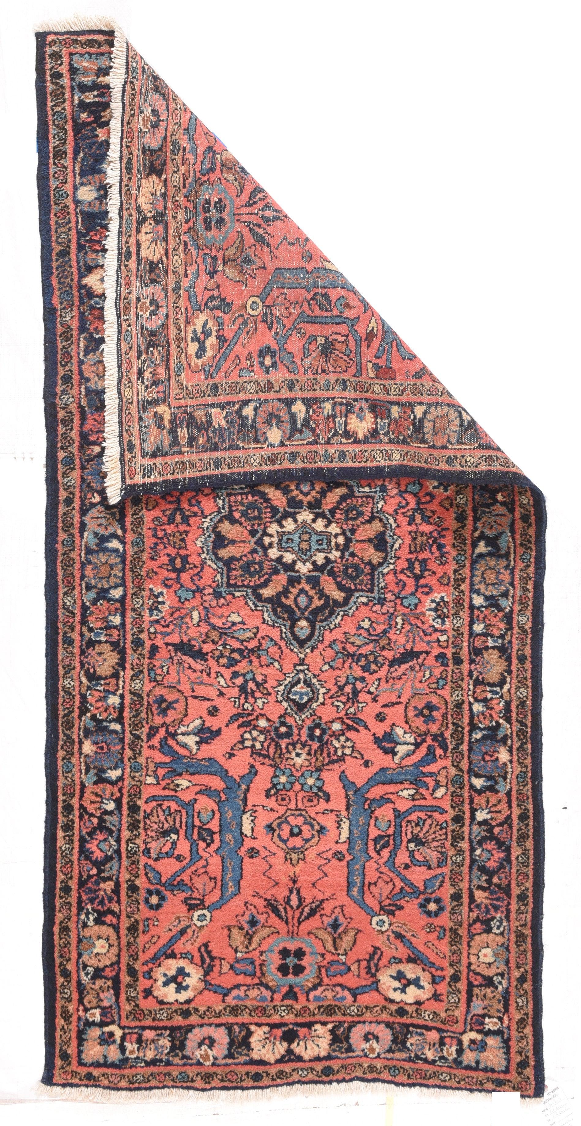 Antique Lilihan Rug 2'8'' x 5'2''. The light coral rose field is centered on a small navy medallion enclosing little lancet leaves around a crew oval rosette. Light blue corner arabesques. Teal accents. Navy border with meander and palmettes.
