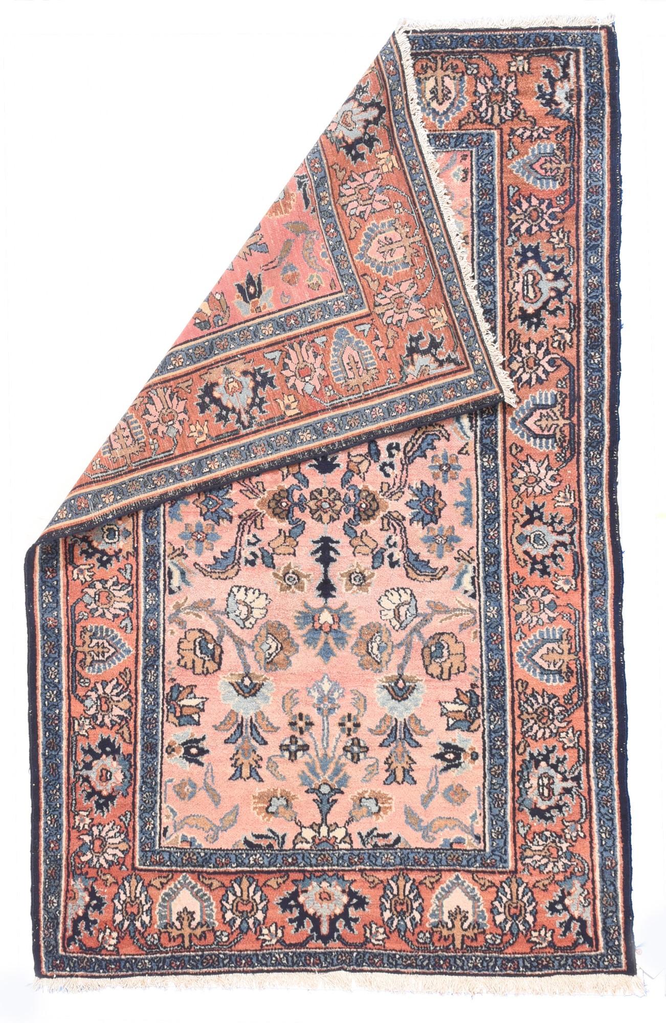 Antique Lilihan Rug 4'1'' x 6'3''. A soft rose border of petal and ragged palmettes in dark and light blue frames the buff field with a centralized pattern of fictional flowers and bitonal leaves. The detached floral pattern shows the influence of
