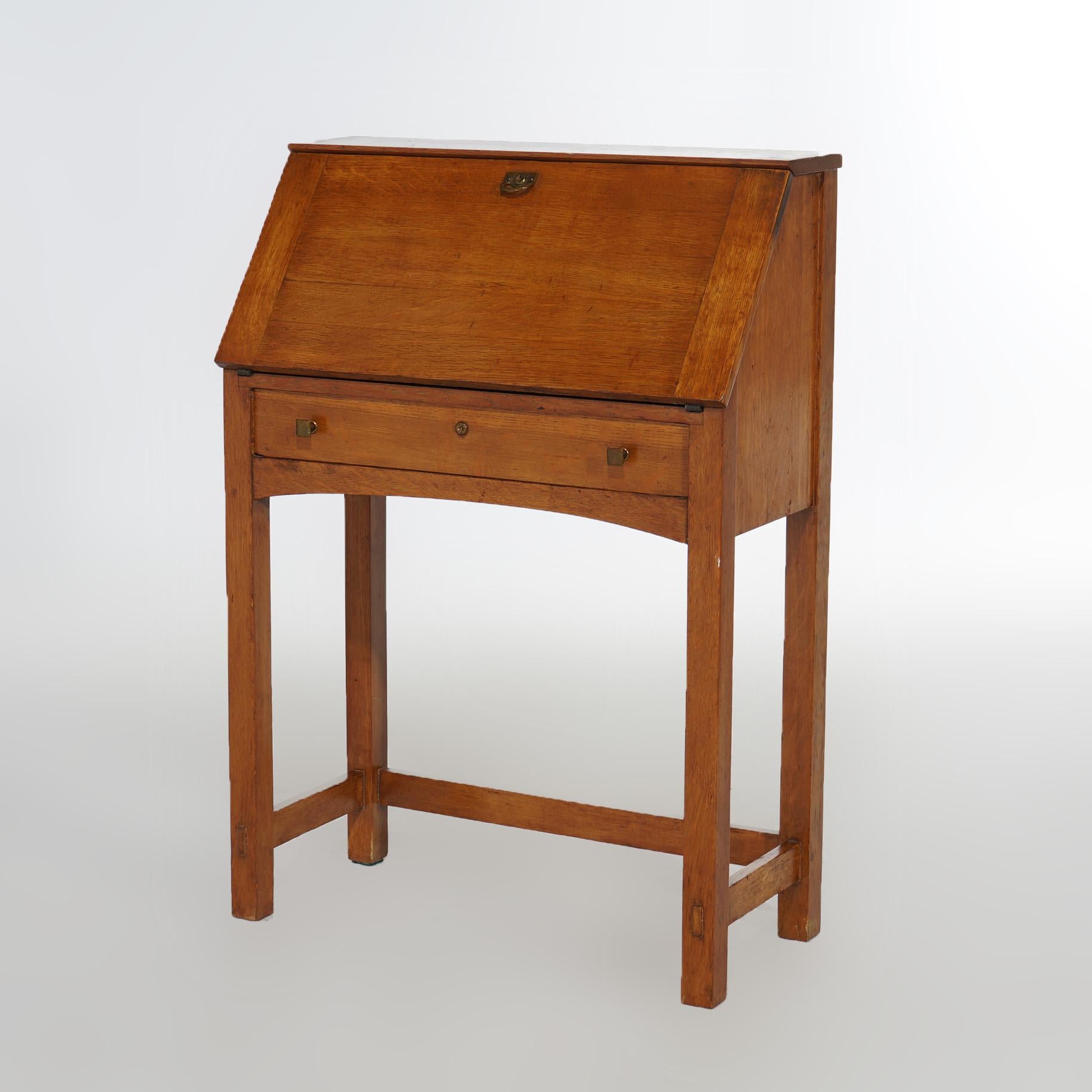 An antique Limbert Arts and Crafts desk offers oak construction with drop front opening to interior with pigeon holes and drawers, raised on straight and square legs, LImbert label as photographed, c1910

Measures - 39.5