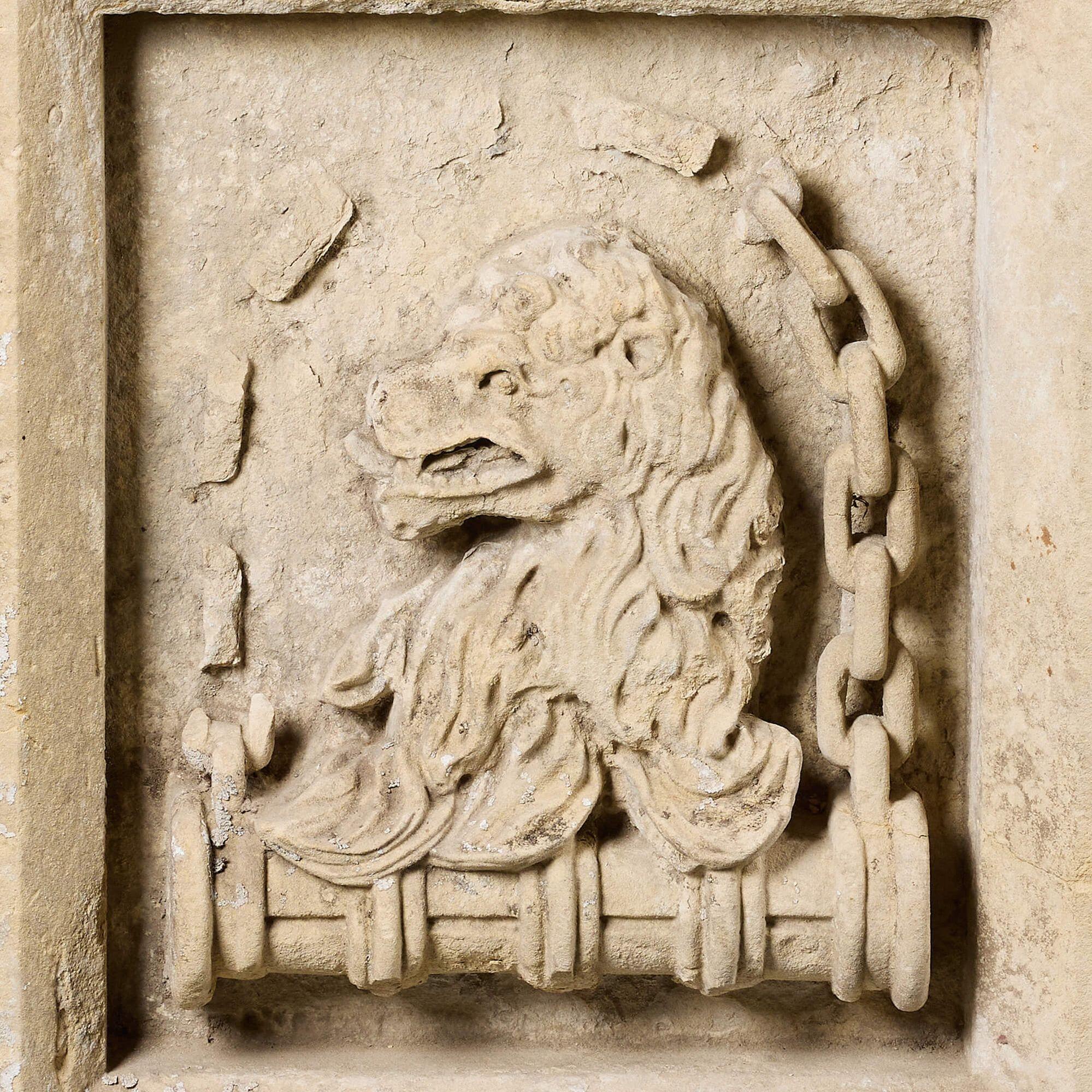 Dating from the 1850s, this carved limestone antique plaque depicts the head of a lion within hand carved chain links, some of which have been lost through the ages. It is more than 170 years old and likely once formed part of a larger piece
