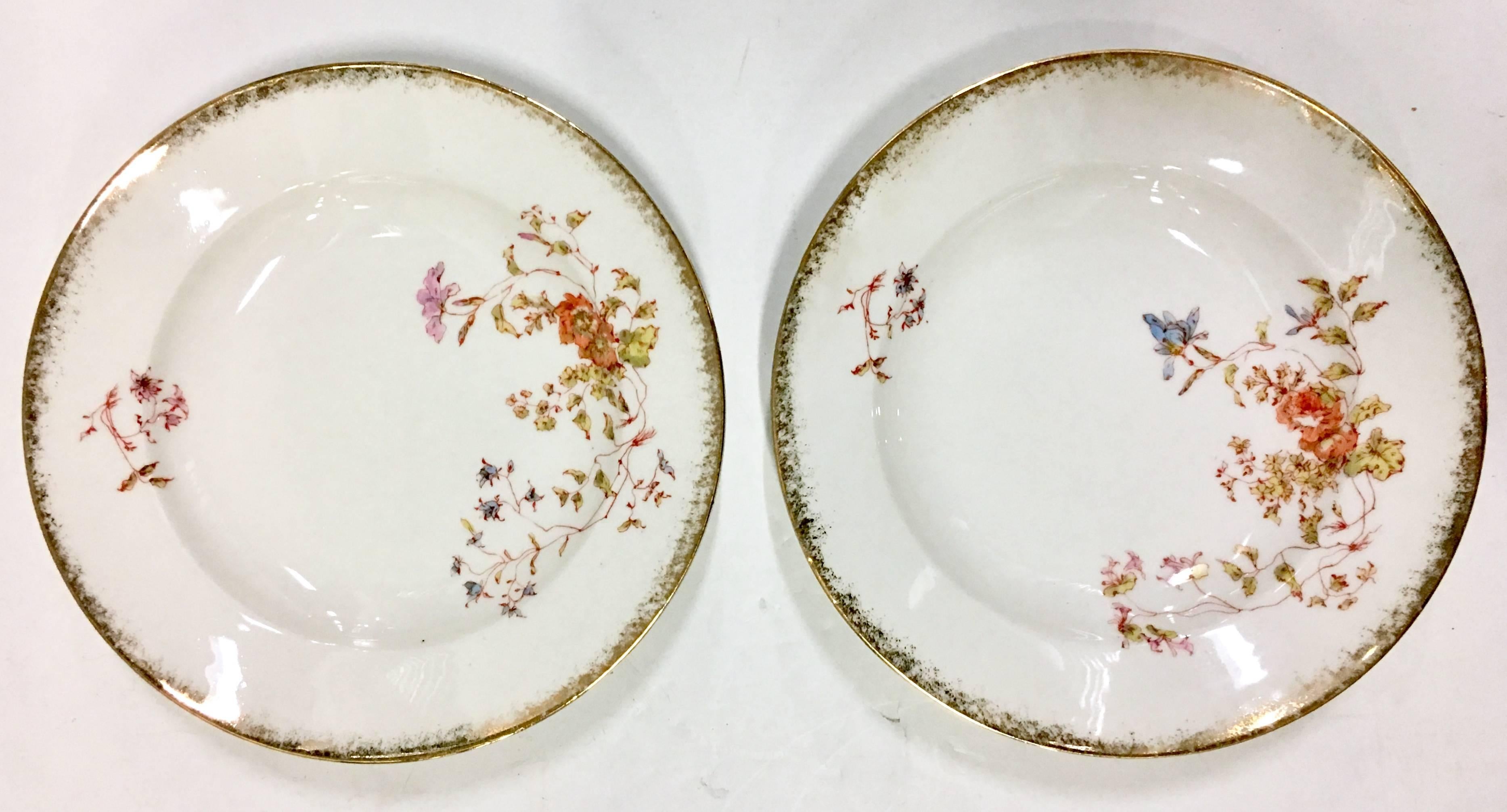 Antique set of ten Limoge France hand-painted rim soup bowls by, Oscar Gutherz-Limoges France. Pattern features a white ground and brushed gold dust 22-karat gold scallop edge rim with a pink, orange and green floral vine pattern. Each piece is one