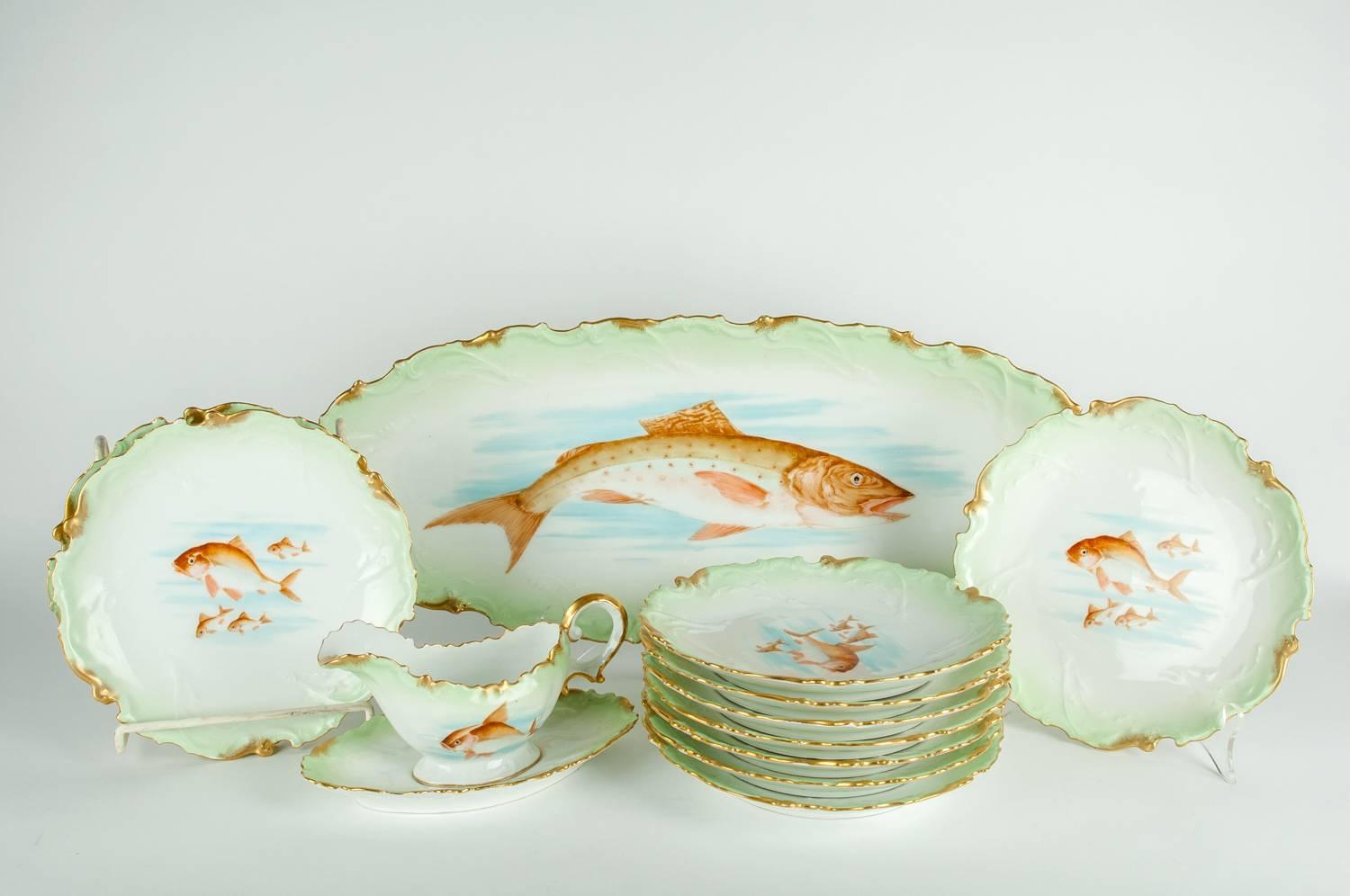 Antique Limoges porcelain with 22-karat gold Victorian era hand-painted 13 pieces fish serving set. Each piece is in excellent antique condition. The set include one large oval platter, ten plates and one sauce boat with under plate. The platter is