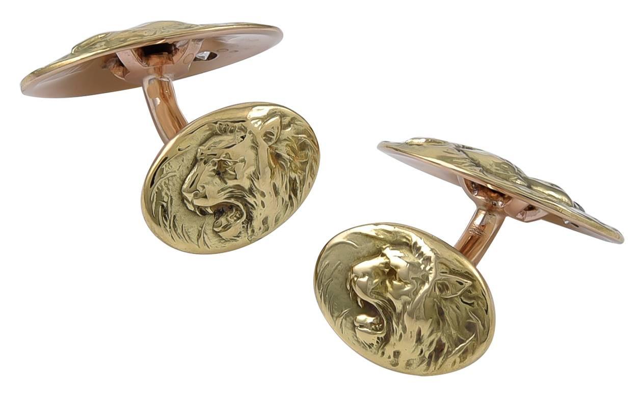 Antique cufflinks, with applied lion and lioness.  The lion is on the front, holding a faceted diamond in his mouth.  The smaller reverse side, connected with a bar, shows the lioness.  14K yellow gold.  Good theme; nicely detailed.

Alice Kwartler