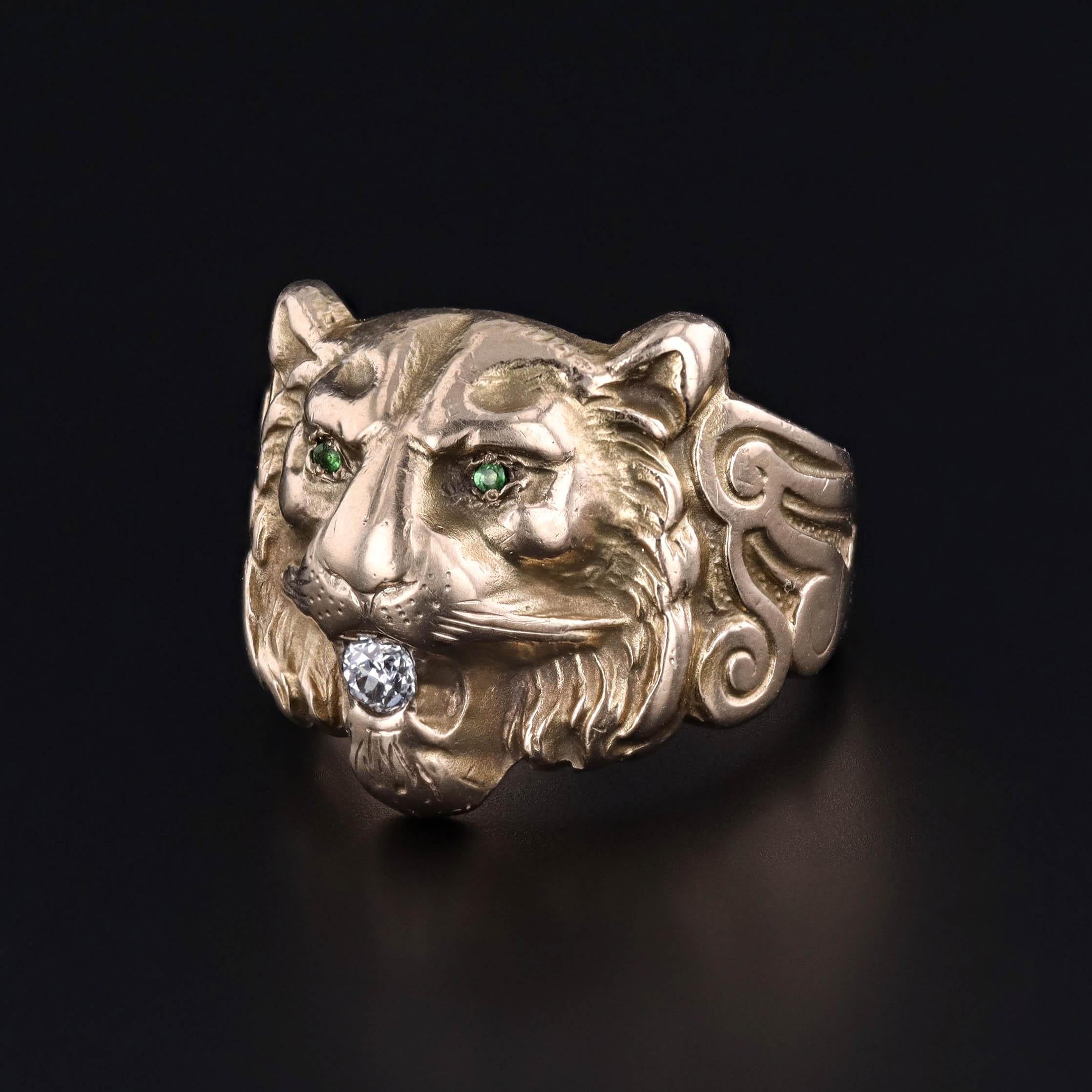 Cette bague ancienne (vers 1910) présente une tête de lion en or 10k avec un diamant dans ses mâchoires et deux yeux en pâte verte (verre).

La face de la bague mesure 0.6 pouces du nord au sud, et elle est en très bon état.  La bague est une taille