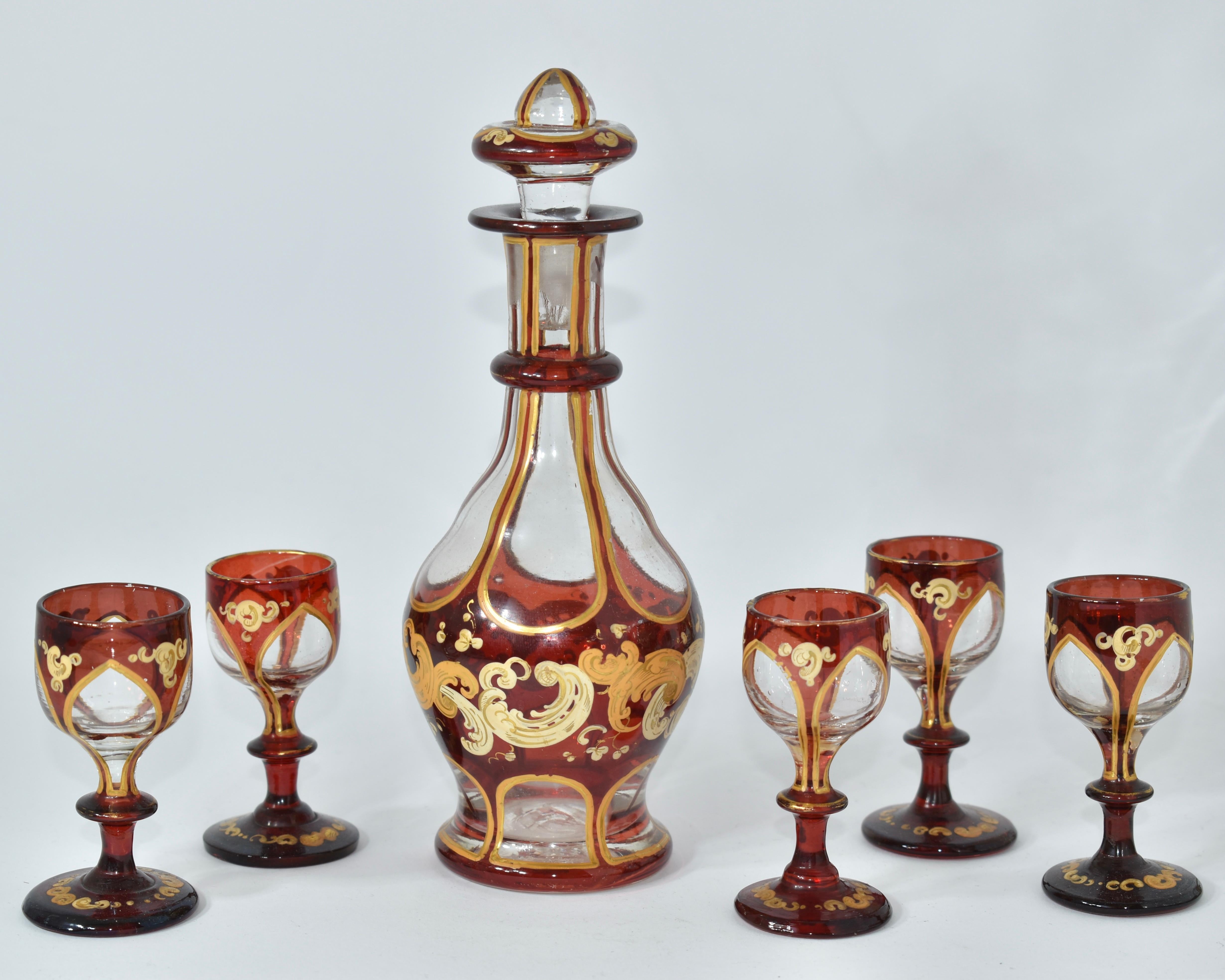 Magnifique set à liqueur, carafe et 5 verres assortis

Verre de Bohème transparent et rouge rubis 

Richement décoré sur tout le pourtour avec des volutes en émail doré et des rehauts de dorure

Bohemia, 19ème siècle