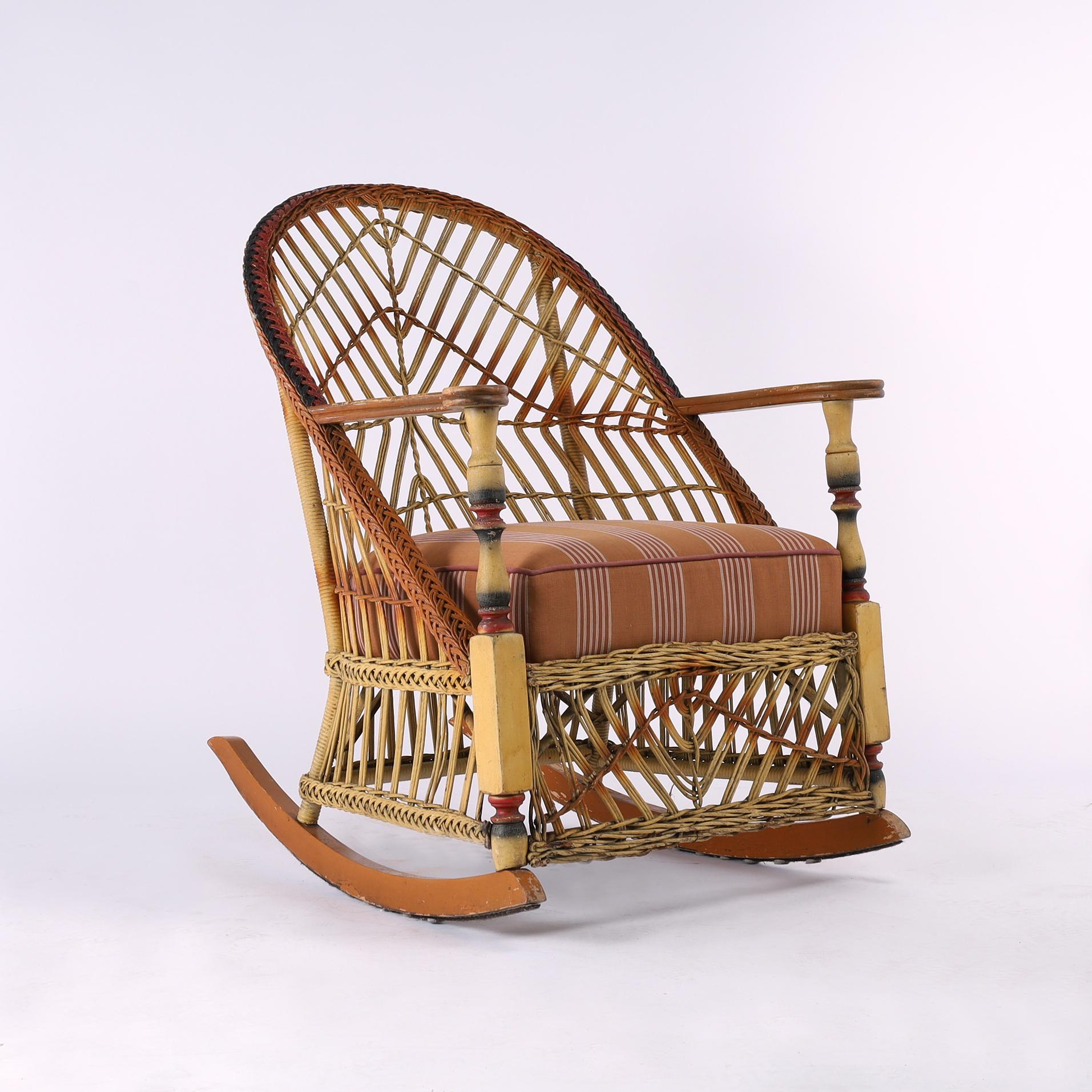 Impressive three piece furniture suite consisting of a sofa, armchair and rocking chair handcrafted with braided frames and stick wicker backs and skirts. Turned posts and wood arms dyed in gradients of red and brown. Signed on the bottom Lloyd