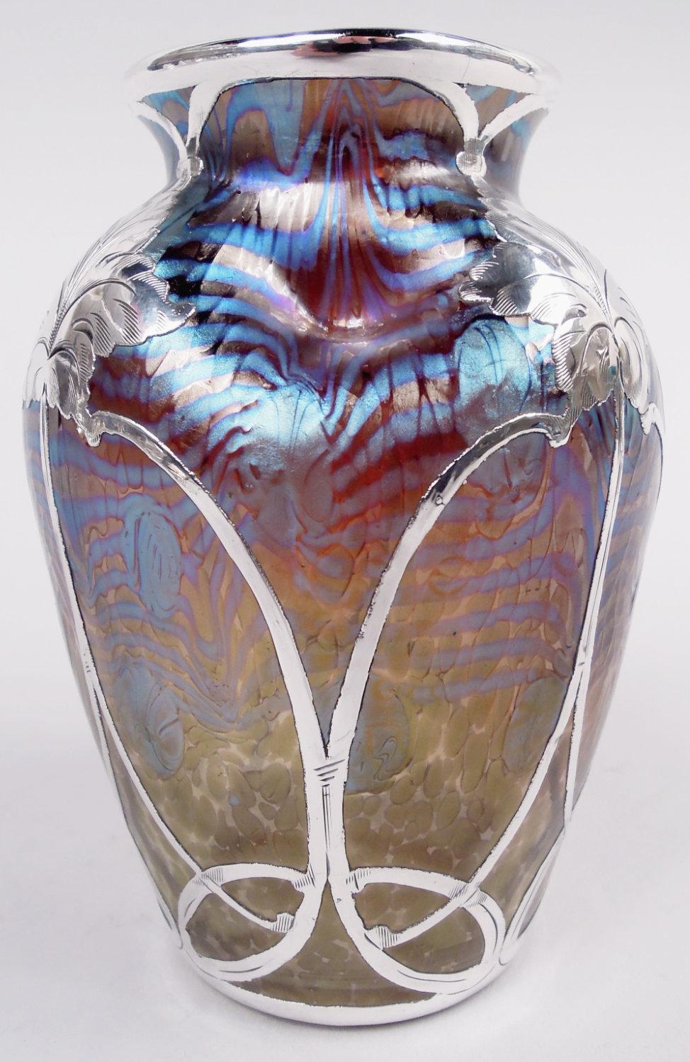 Vaso in vetro Art Nouveau con sovrapposizione di argento inciso dello storico Loetz, 1900 circa. Ovoidale con spalla schiacciata. Motivo di sovrapposizione composto da ovali verticali con anelli intrecciati che salgono fino al gambo di una foglia.