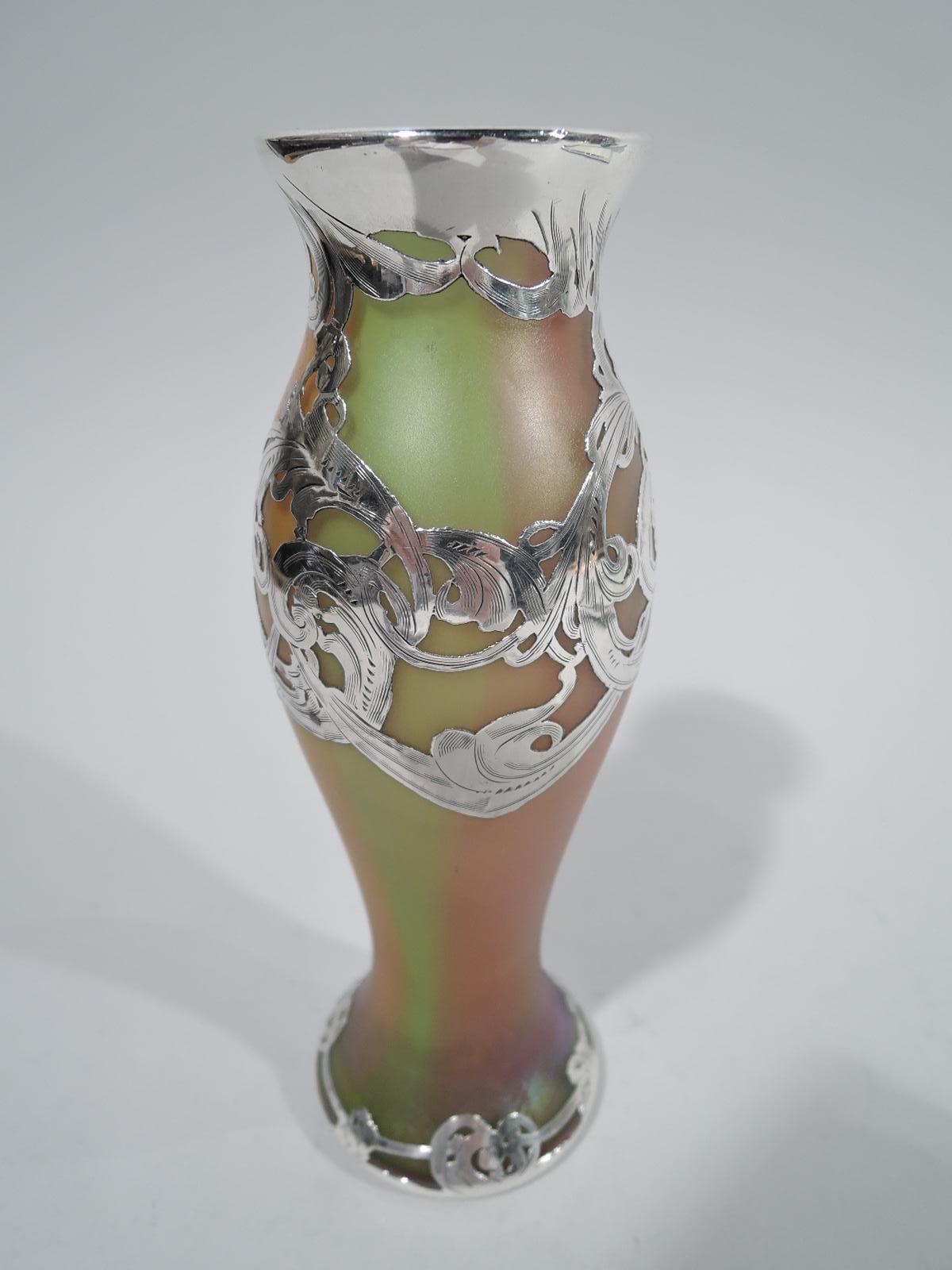 Turn-of-the-century Art Nouveau glass vase by historic Loetz with engraved silver overlay. Baluster with flared mouth and spread foot. Rinceaux overlay with pendant swags, and loosely spaced-out scroll border at foot. Iridescent rainbow glass with
