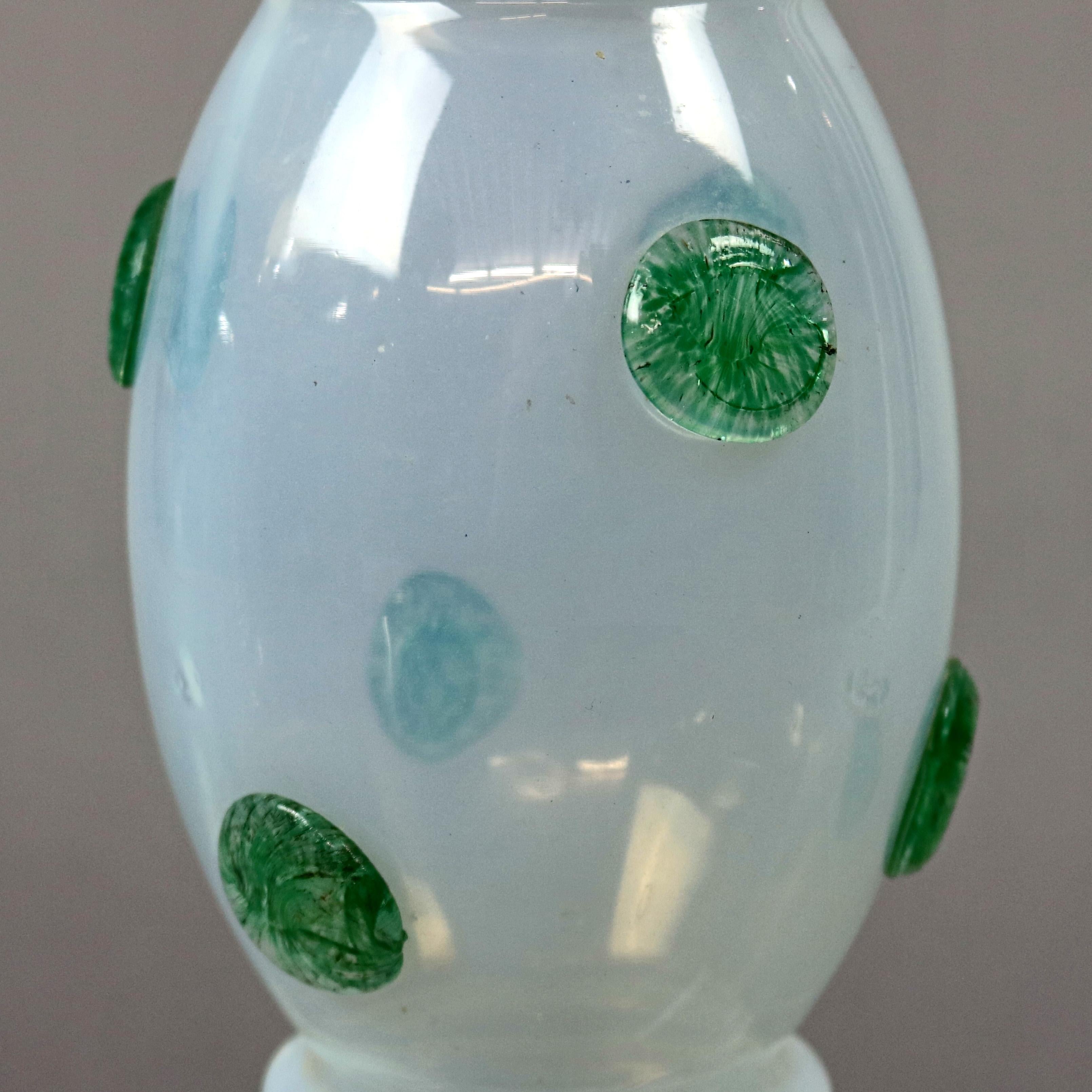 An antique handcrafted art glass vase in the manner of Loetz offers opaque glass in bulbous form with applied green glass polka dot decoration, flared mouth and raised on stepped base, whimsical elements, circa 1920


Measures: 8.75