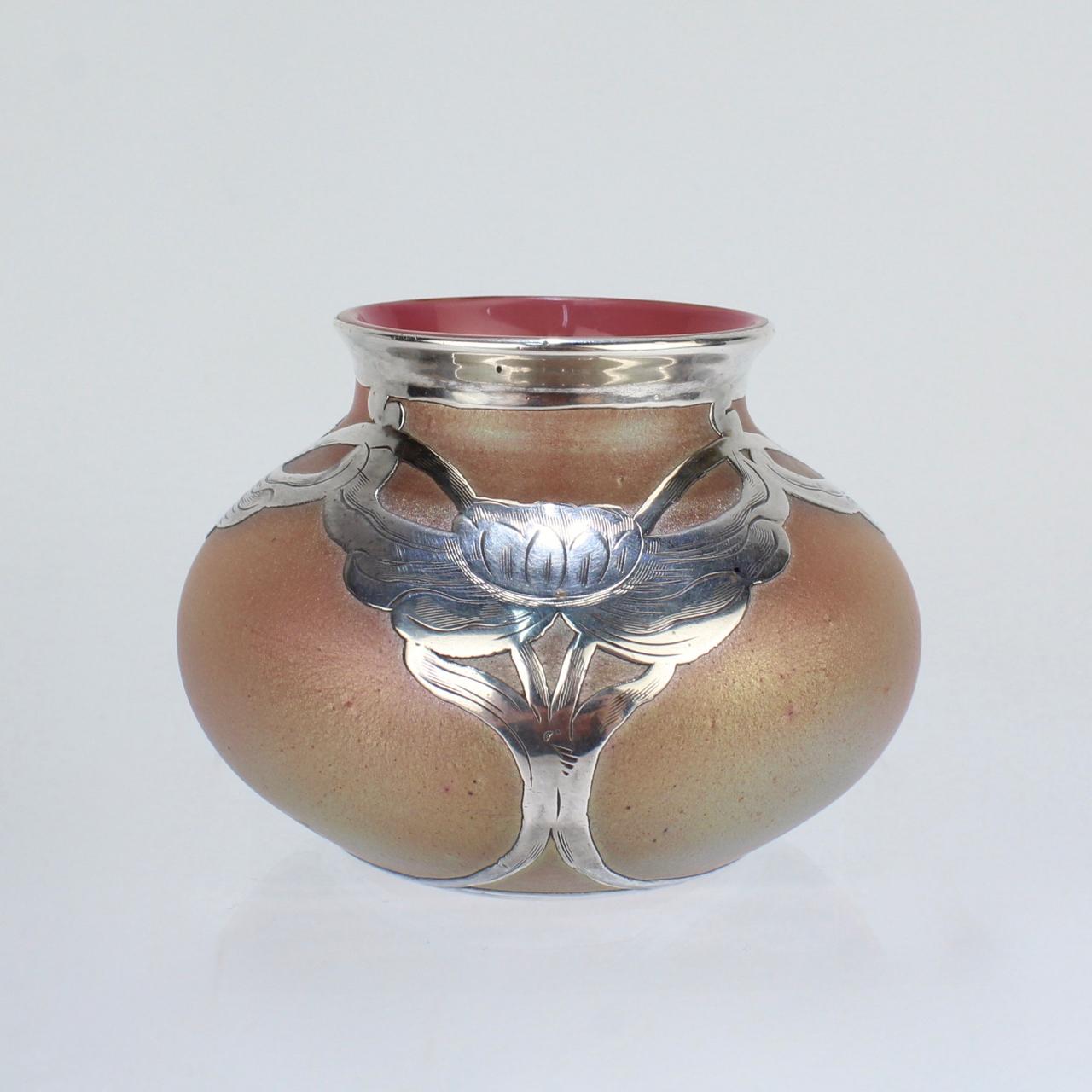 A good, small scale Art Nouveau period Loetz art glass cabinet vase with thick sterling silver overlay decoration.

The glass with a Silberiris finish and the silver with engraved decoration.

The silver is marked at the base for La Pierre Mfg.