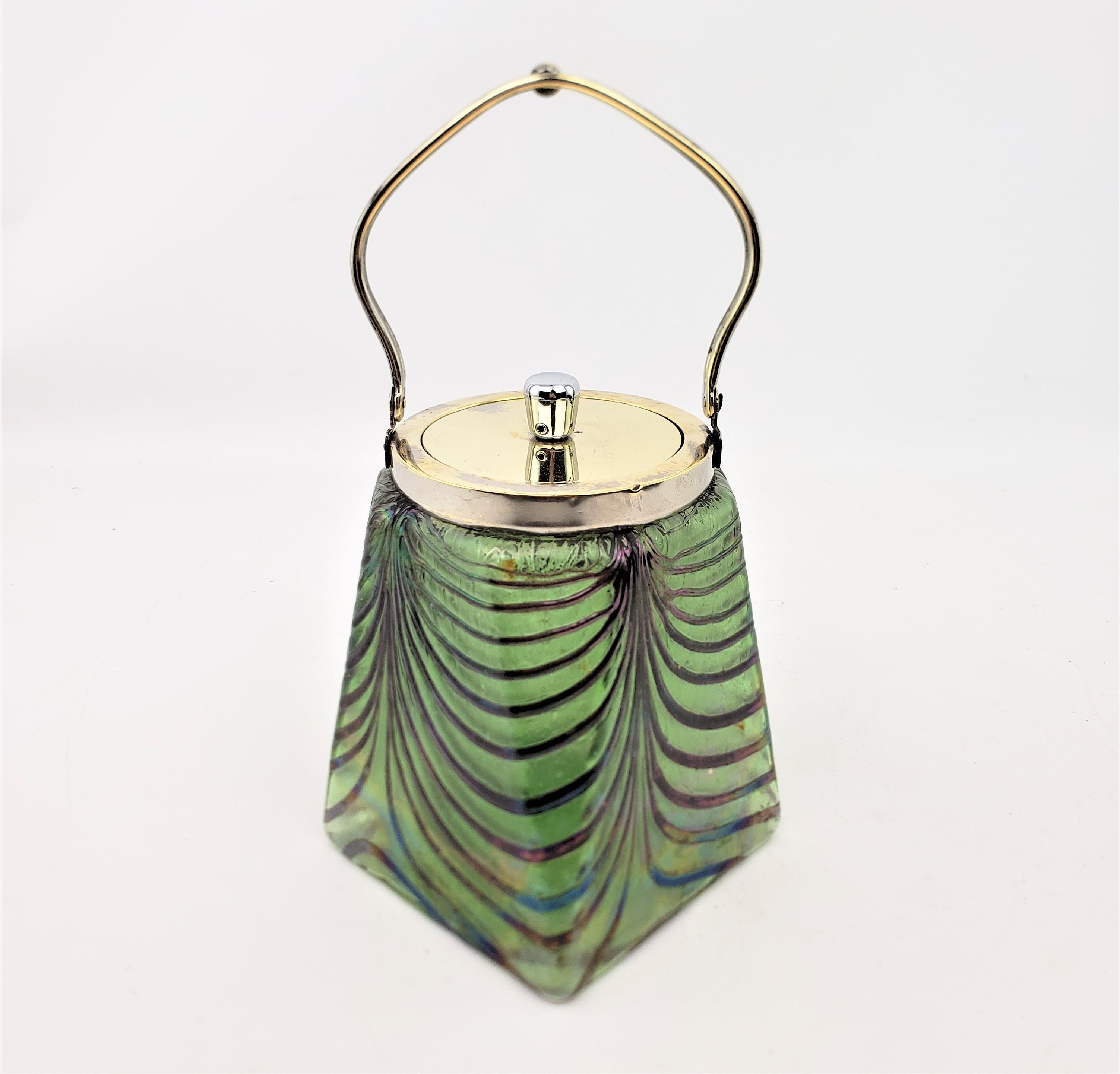 This antique art glass and silver plated biscuit barrel is unsigned, but presumed to have originated from Austria and done by one of the various contemporary art glass producers of Loetz and done in the period Edwardian style. The body of the