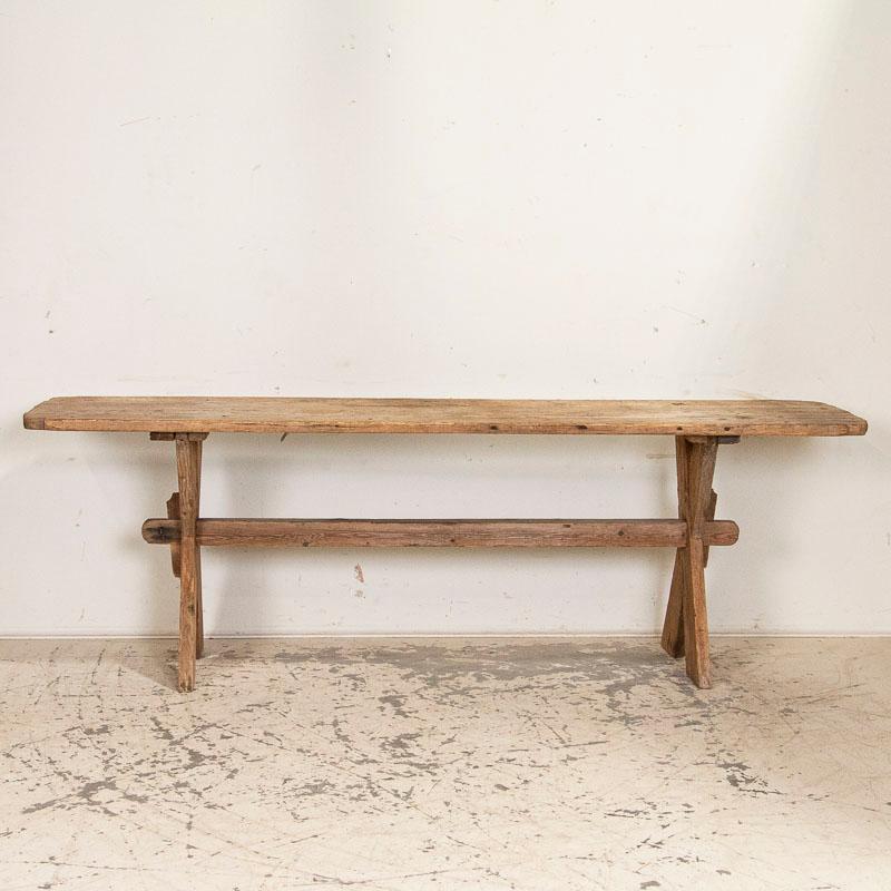 This long pine trestle table came from the Swedish countryside. The patina of the pine, wear and distress including some cracks along the top do not impact the integrity or functionality of the dining table, but rather create the character one finds