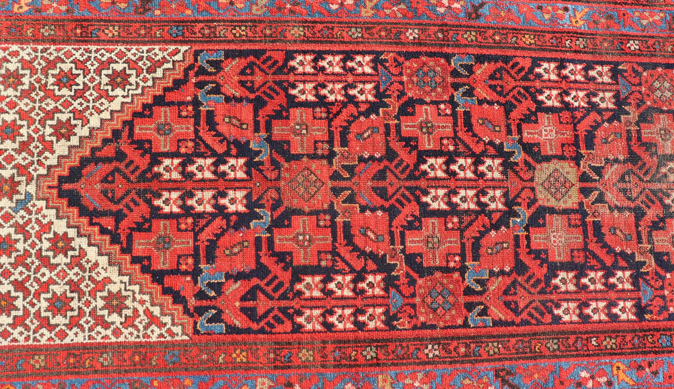 This gorgeous antique Malayer Runner features a stunning all-over geometric Herati design set upon a Dark Blue background. The patterns are surrounded by a variety of motifs. The entirety of the piece is enclosed within a complementary, multi-tiered