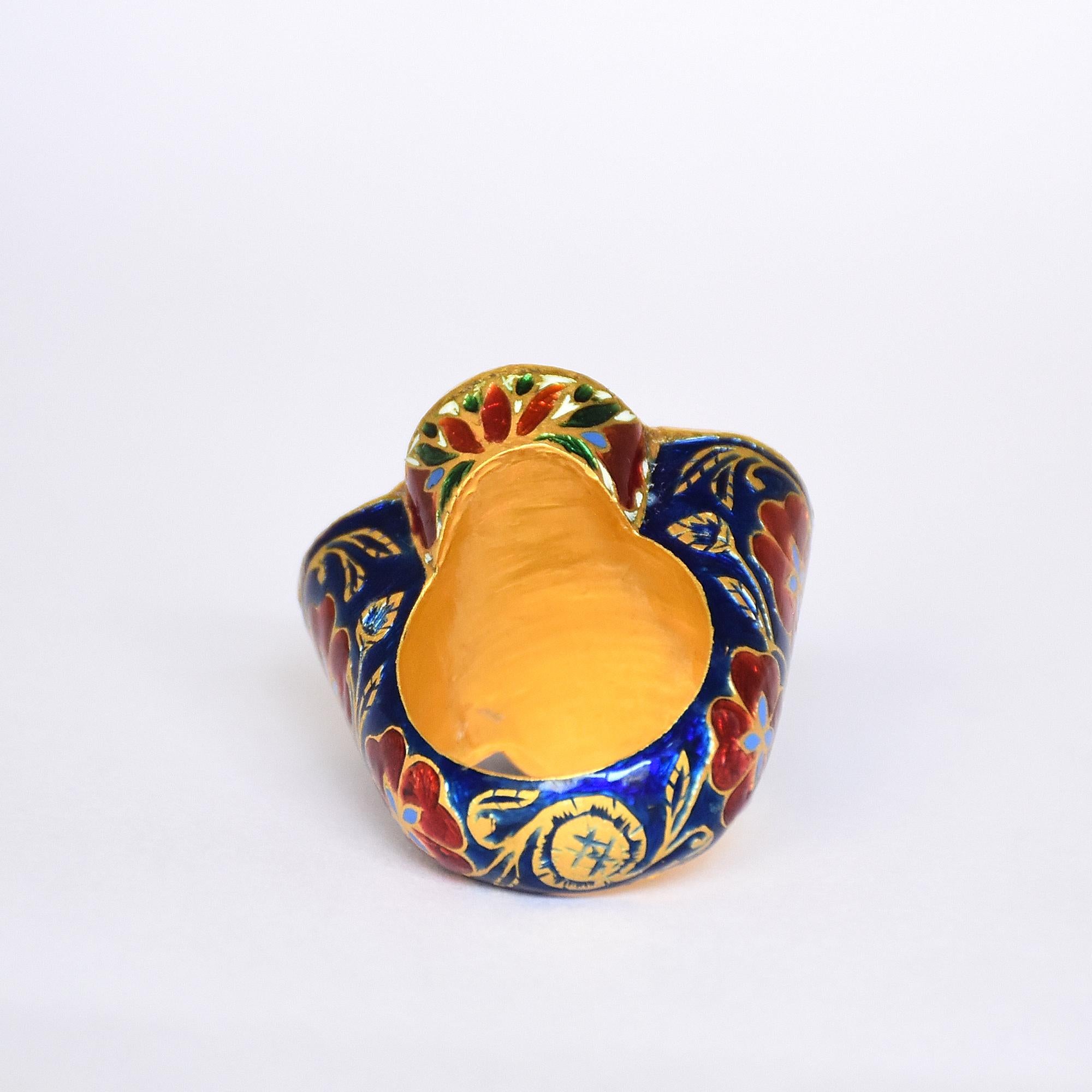 Traditional Mogul style Kundan Meena Navratna gold ring is hand enameled on band with natural ruby, emerald and diamonds. The ring is set with real flat uncut Diamond Polki. The craftsmen has hand engraved flower and petal motifs on band. Carrying