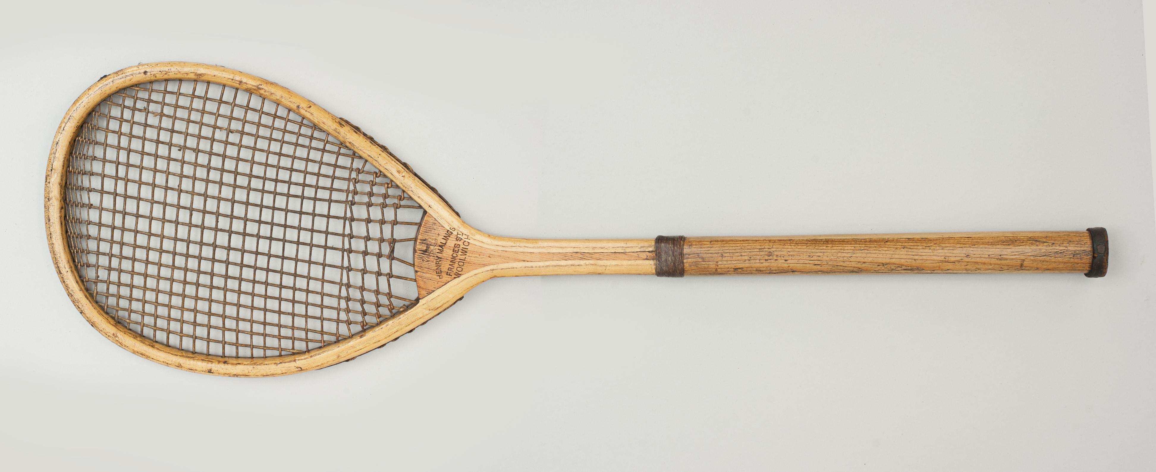 A rare, early lopsided (tilt head) lawn tennis racquet in excellent original condition. The ash frame is in very good condition with concave wedge stamped with maker's mark and the Royal Coat of Arms. The period thick gut stringing is in good