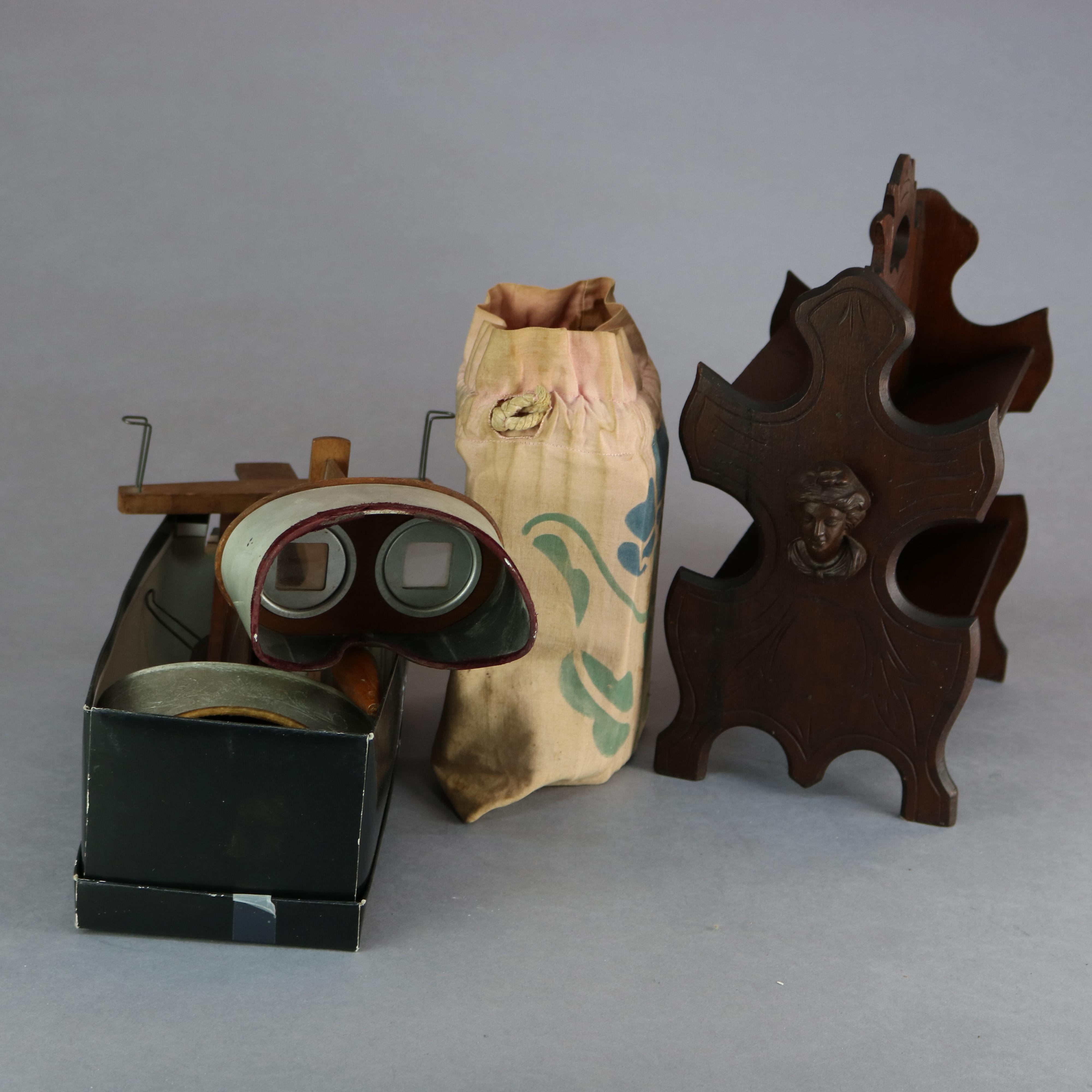 An antique stereo viewer set by Underwood & Underwood includes two viewers (one with logo), cards and walnut stand with carved Jenny Lind mask on shaped sides, c1890

Measures: 13