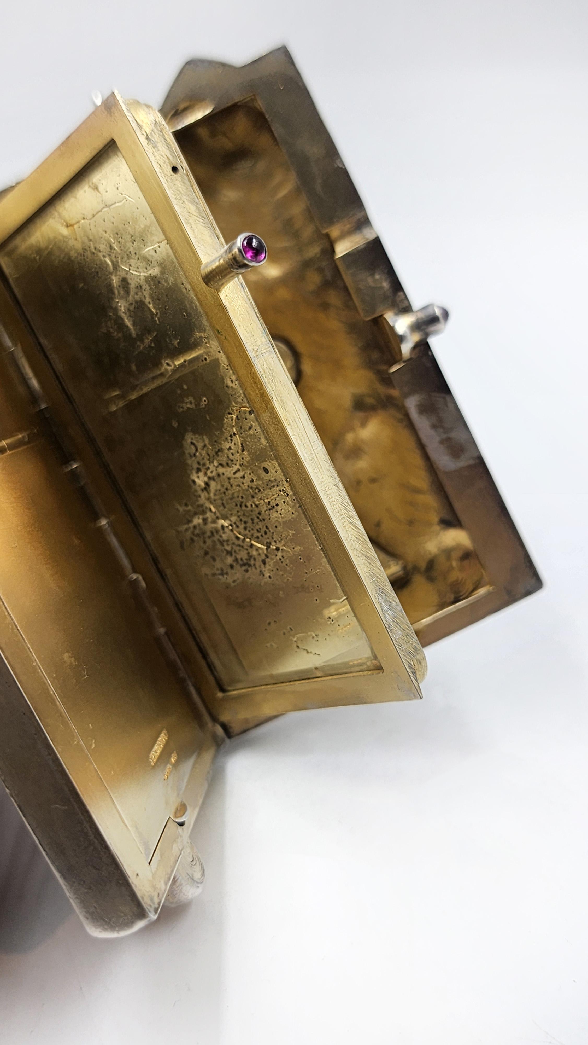 Compacto de plata y rubíes para tocador de gato antiguo Louis Kuppenheim
Magnífica minaudière antigua alemana de plata maciza adornada con un gato de plata grabado en relieve profundo en la parte delantera de la caja, con el lomo del gato en la tapa