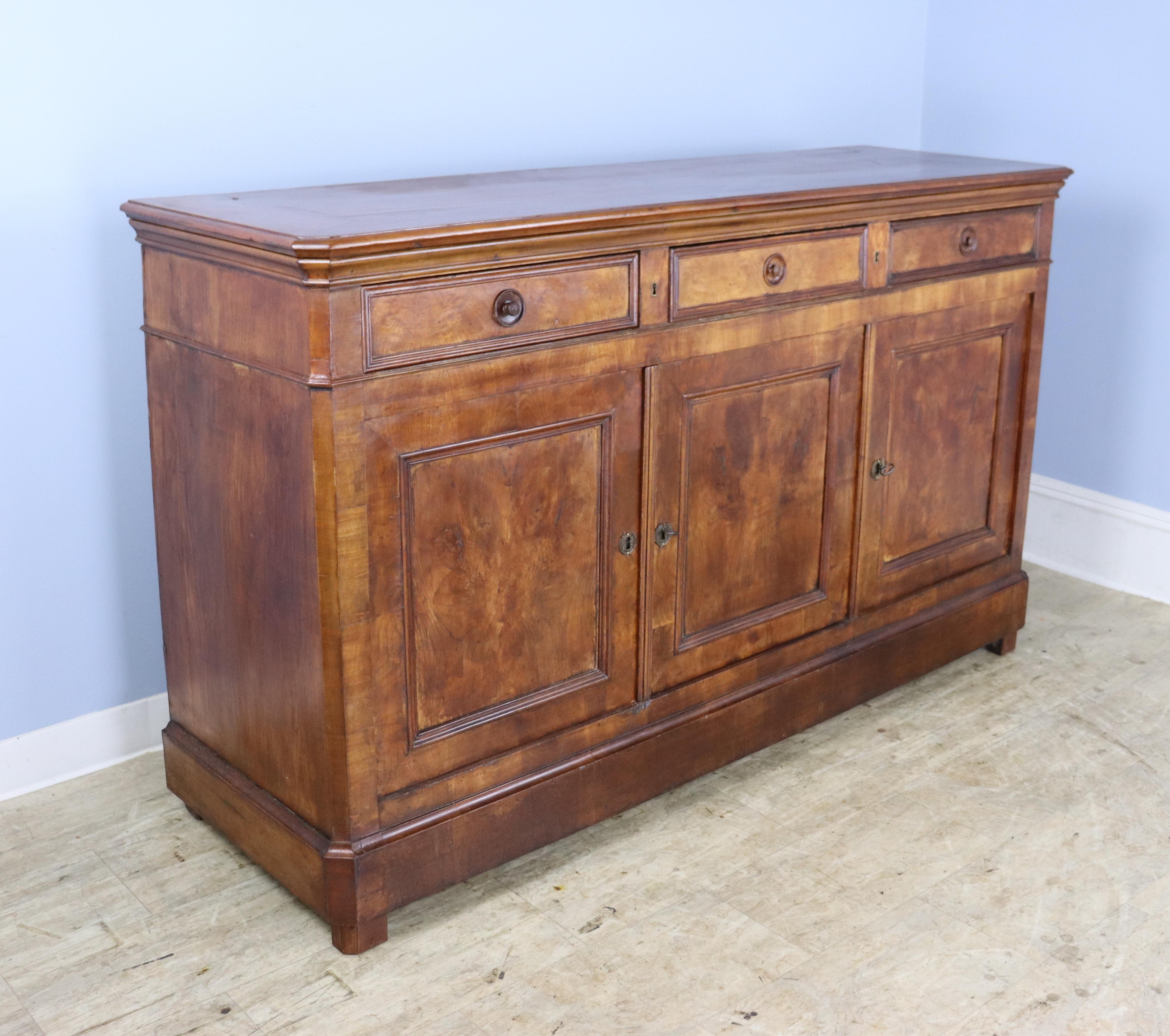 Very good, long three-door enfilade with beautiful elm grain highlighted by dramatically colored inset panels on the doors. Glorious glow and patina. This piece has Classic Louis Philippe details including canted corners and lovely beading around