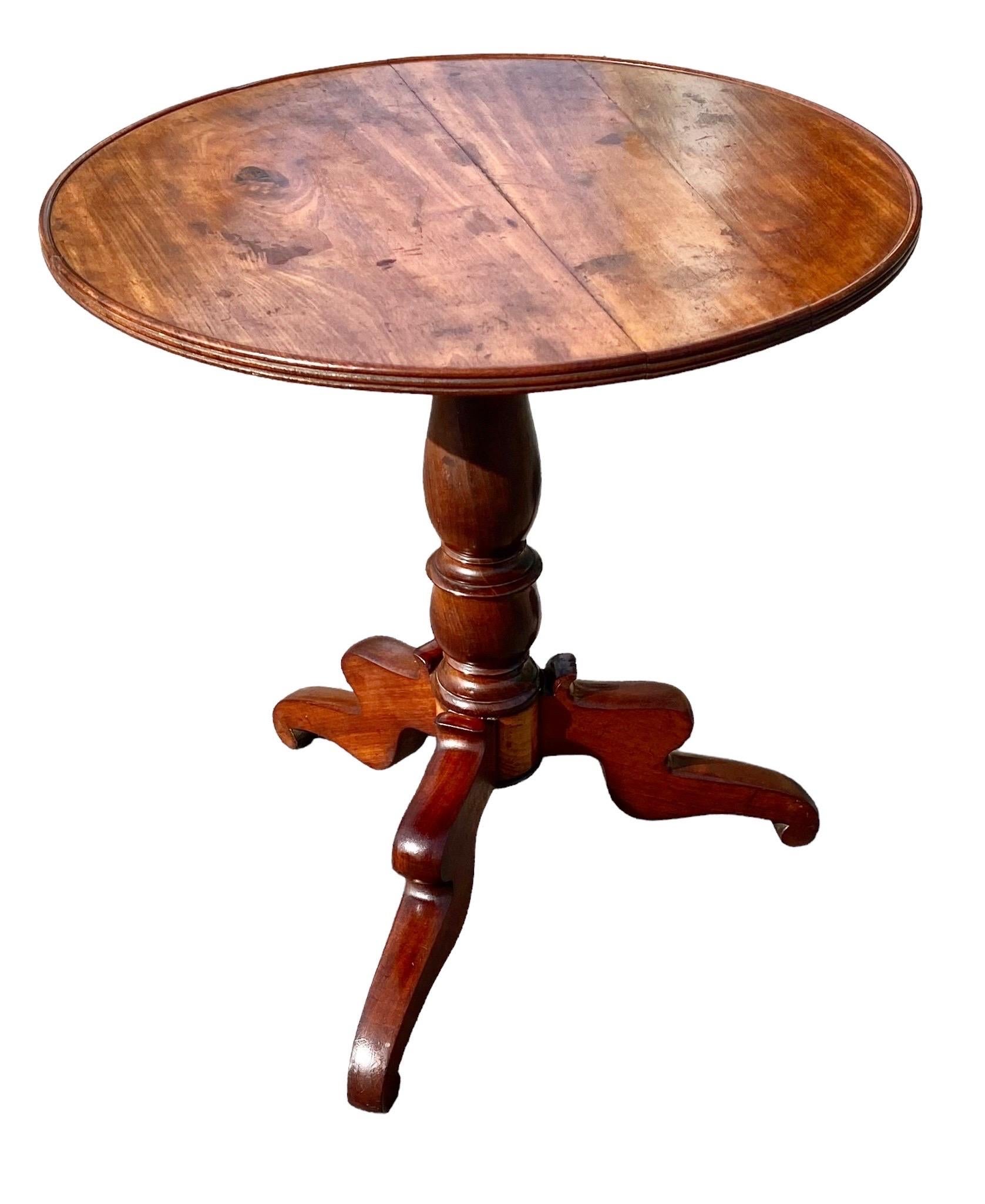 A period Louis Philippe solid old growth cherry wood revolving tilt top supper or accent table having a beautiful patina and knots in a two board top with a reeded edge. The hand turned tripod base with beautifully shaped legs. Circa 1860

It is a