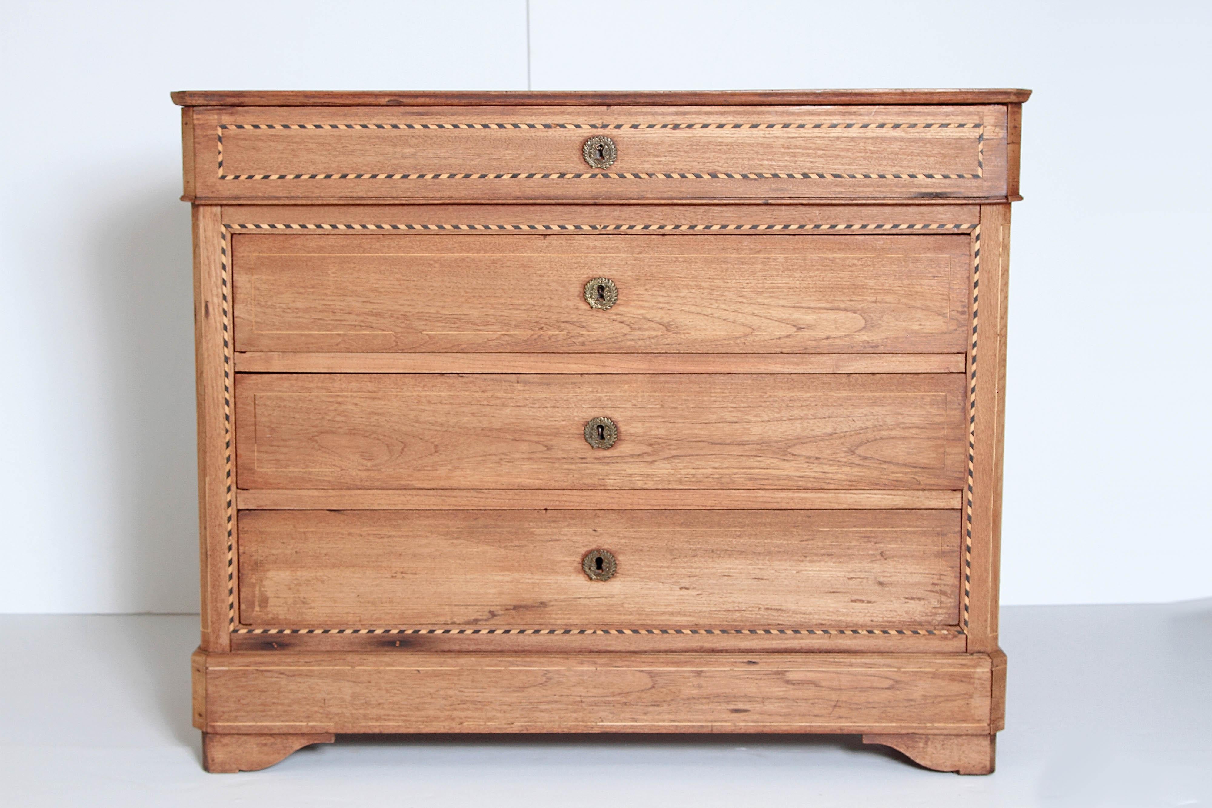 A handsome example of the Louis Philippe four-drawer bleached walnut chest. Note the beautiful alternating black and light inlaid border around the top drawer and framing the lower three drawers. The chest comes with one key that is used to open all