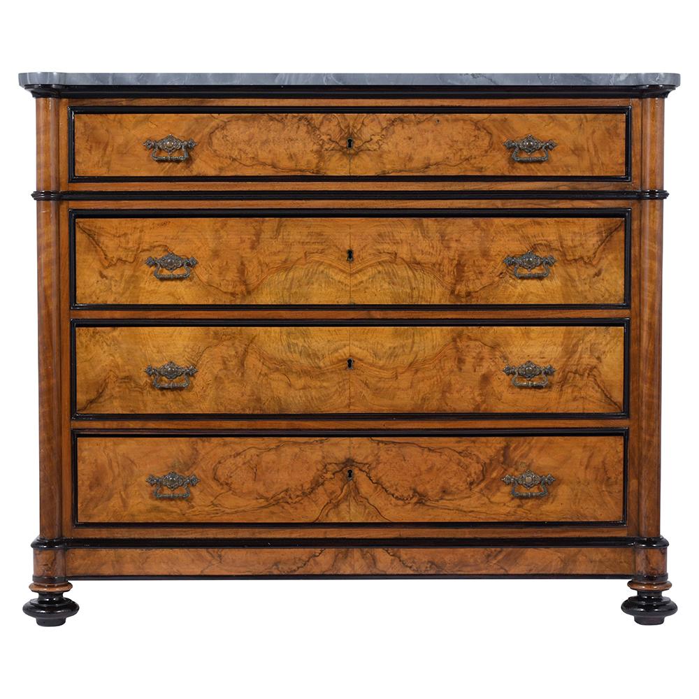 An Extraordinary French Marble Top Commode crafted from solid wood is covered in elegant walnut veneer with ebonized molding accents and a newly lacquered finish. This Elegant Dresser features its original grey marble top, 4 dovetailed drawers with