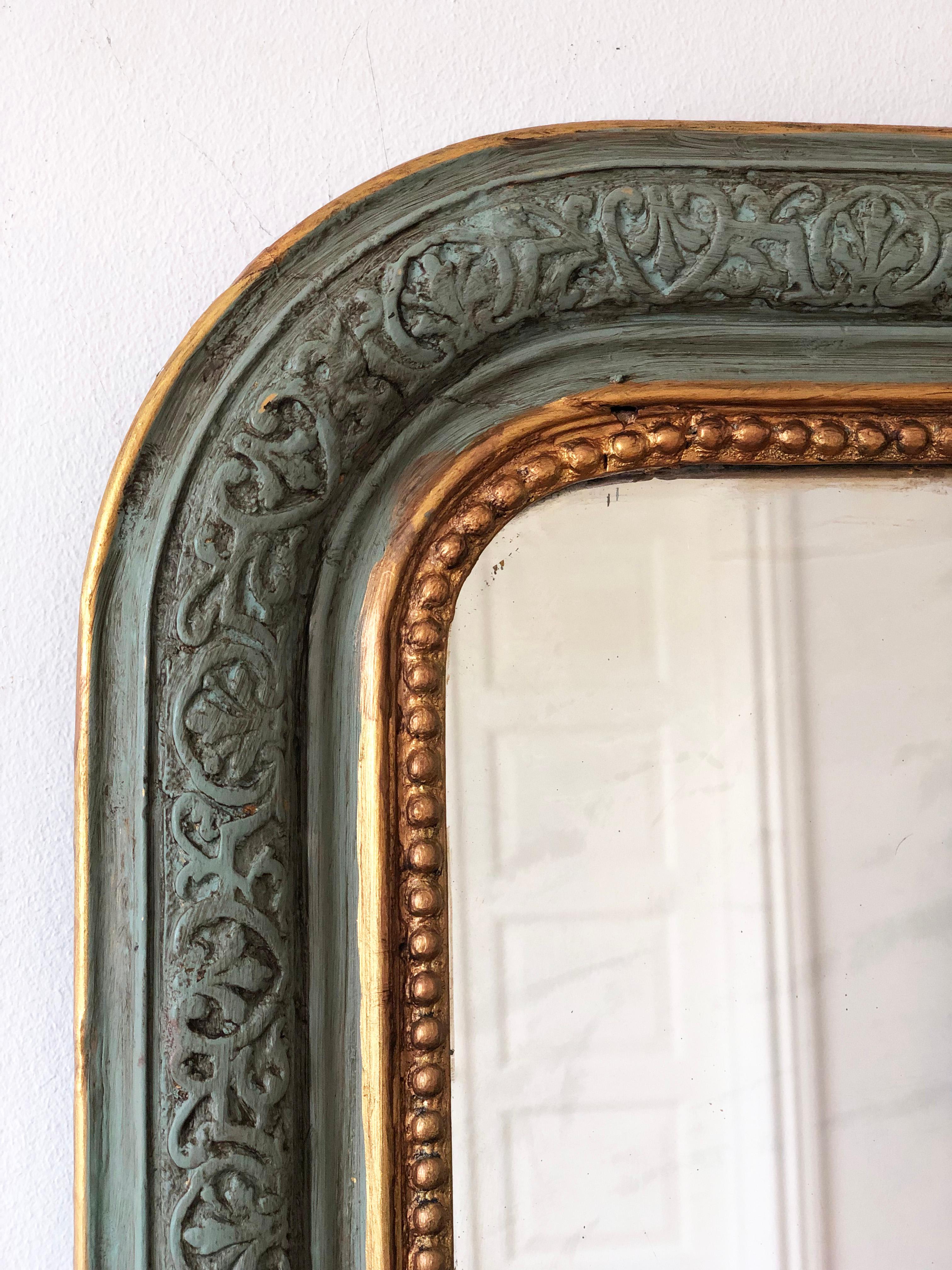 Miroir français Louis Philippe, datant de la fin du 19e siècle.
Le miroir est doté d'un cadre vert sculpté raffiné avec des garnitures en perles dorées douces et un dessus gracieusement incurvé, exsudant une élégance et un charme intemporels.

Objet
