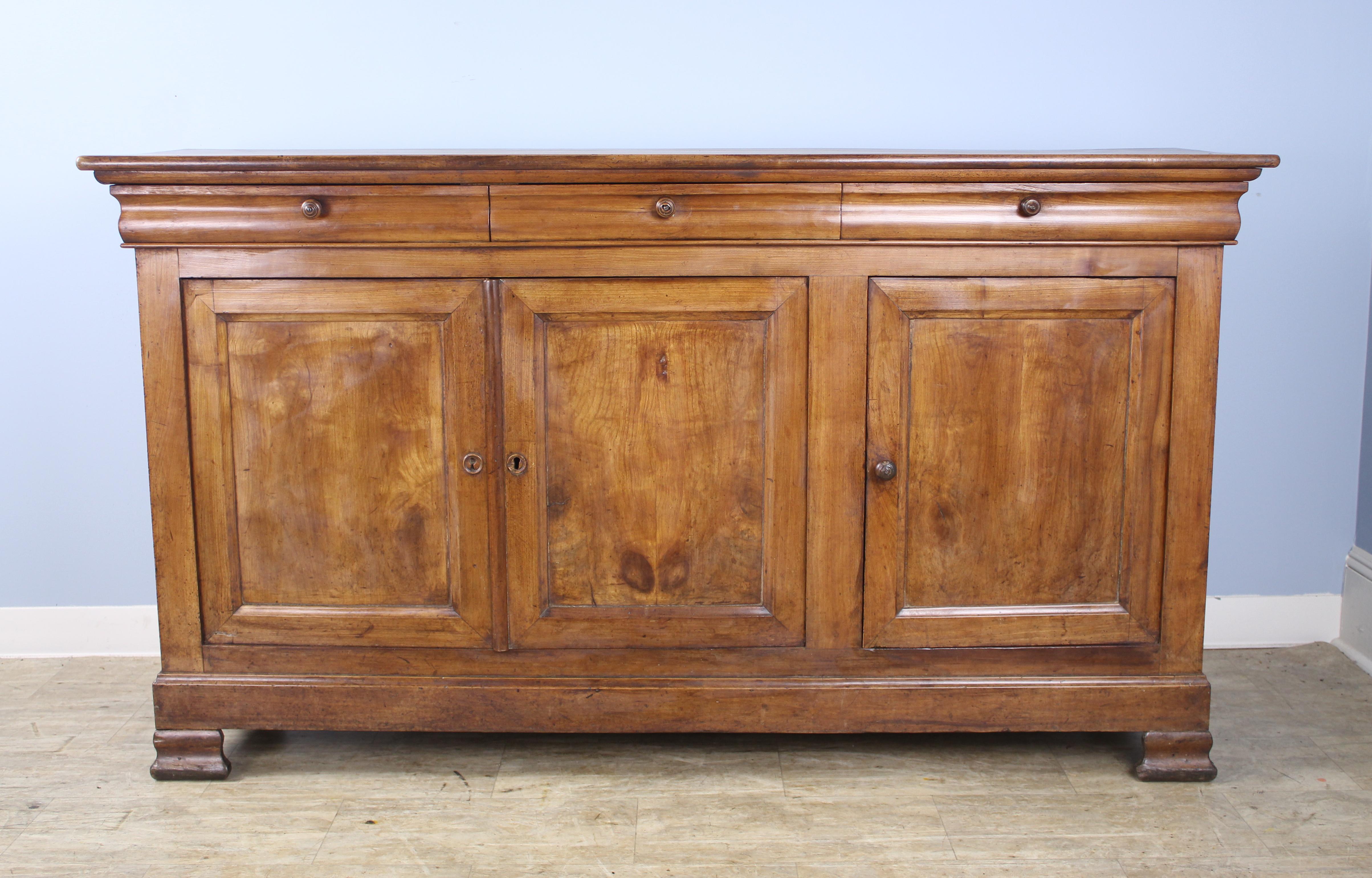 Very good, early long three-door enfilade with beautiful light and dark grain highlighted by well grained inset panels on the doors. Good glow and patina. This piece combines elements of both the Louis Philippe and Directoire styles, including