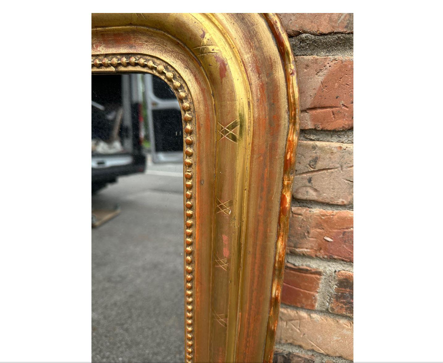 This is a gorgeous 19th century Louis Philippe mirror. The mirror has a beautiful gold beaded design on the inner border, as well as hand carved designing along the border as well.
This mirror also has a unique scalloped outside edge that is not