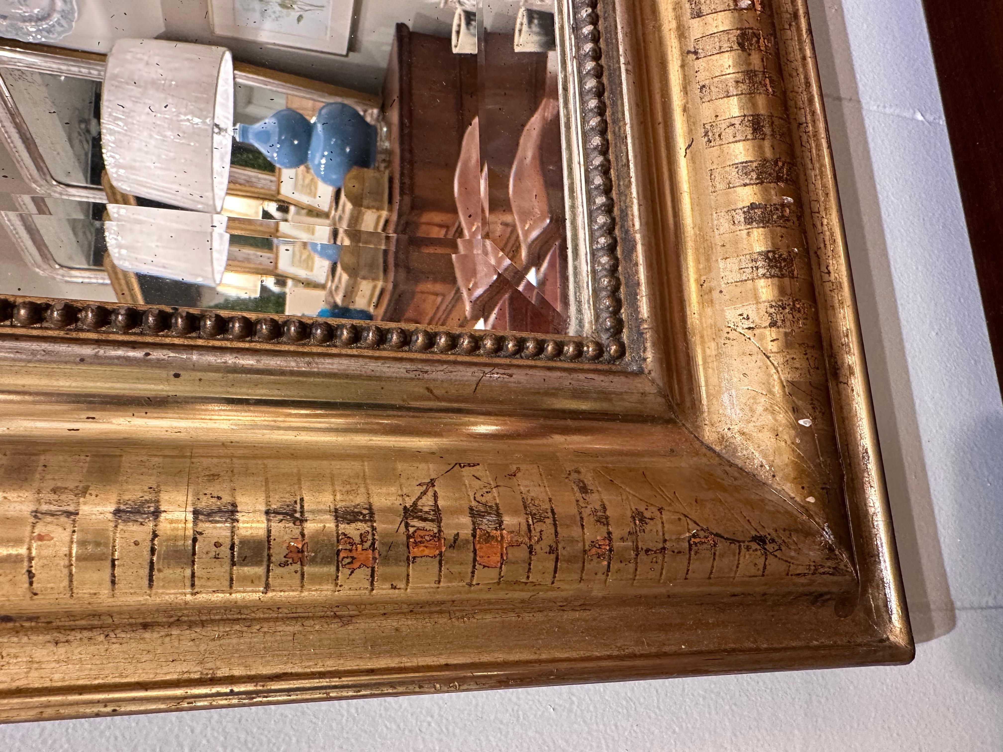 Dieser exquisite antike Louis-Philippe-Spiegel mit vergoldetem Finish verleiht jedem Raum mühelos zeitlosen Charme. Seine kunstvollen Details und sein klassisches Design machen ihn zu einem fesselnden Mittelpunkt, der Stil und Geschichte in einem