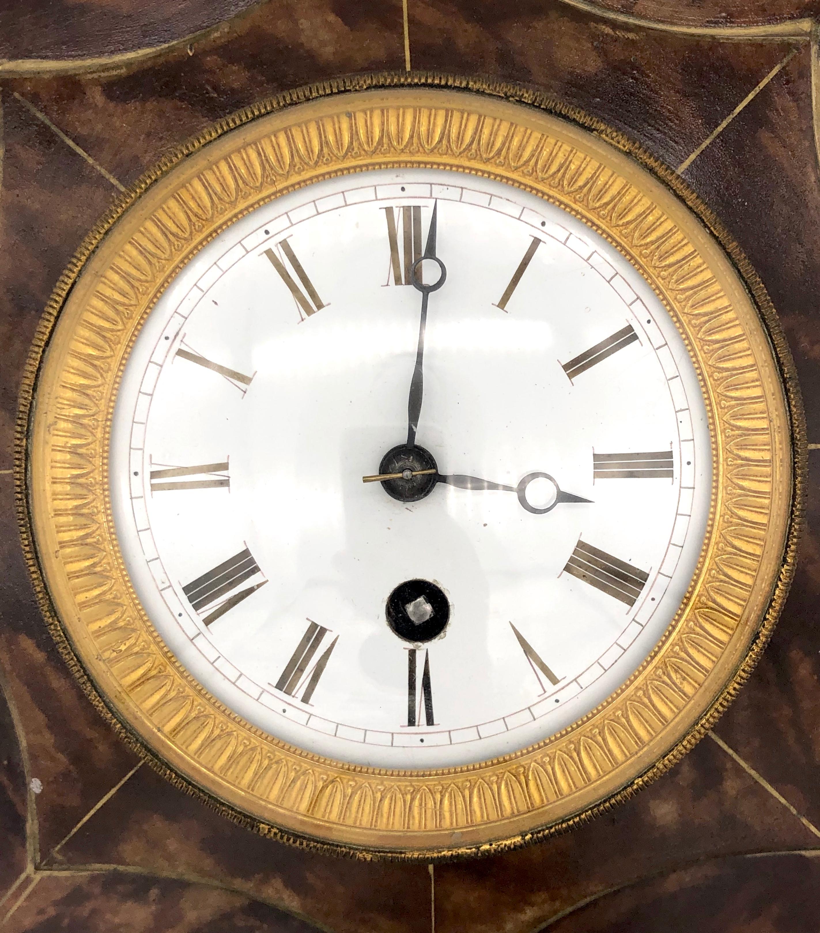 Elegant octagonal wall clock with an eight day movement. The case of the clock is made out of painted metal. The dial is enameled and the clock has bronze fittings.