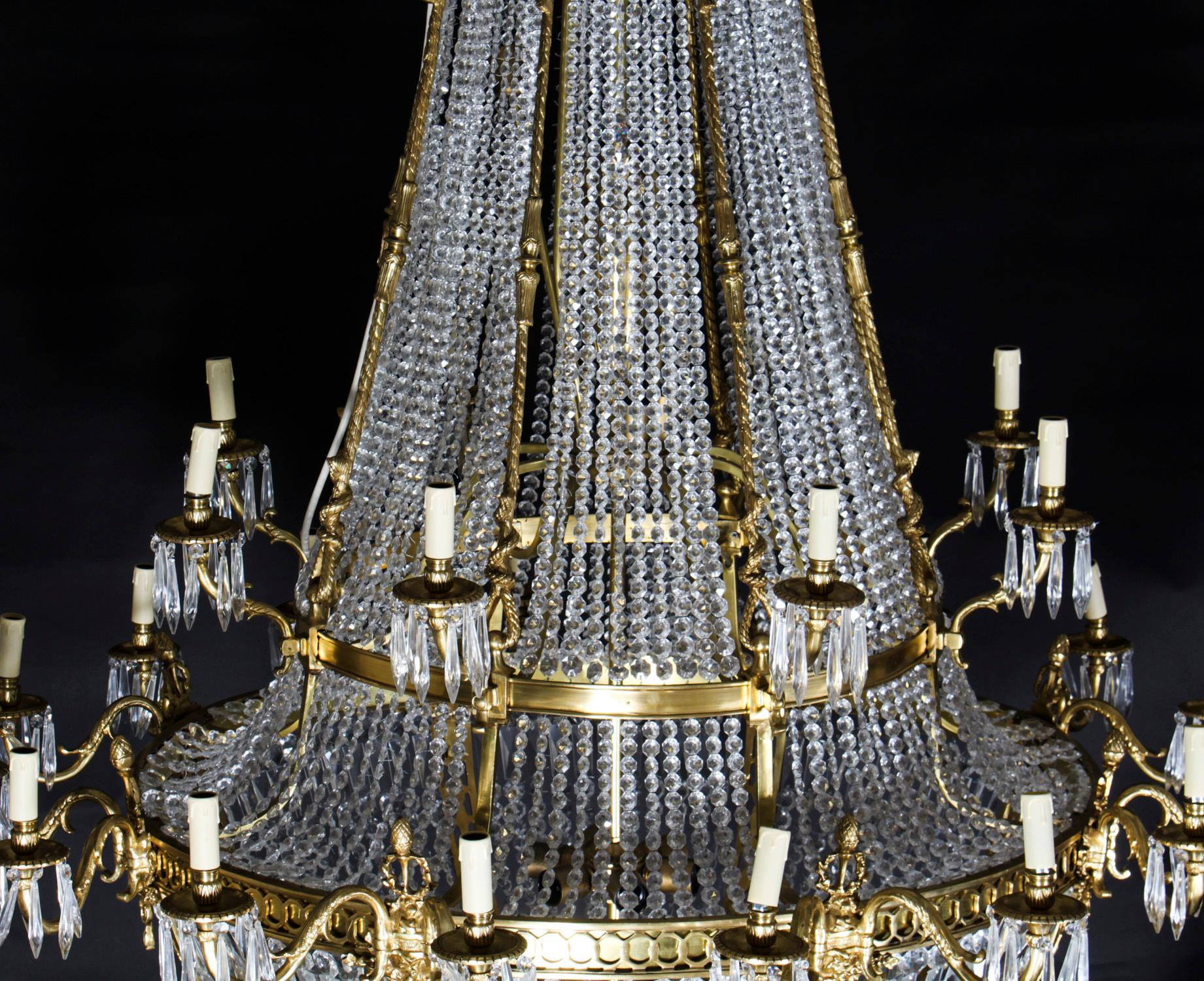 This is a beautiful Louis Revival 36 light ballroom cut crystal and bronze tent chandelier, circa 1920 in date.

The cut crystal tent and bag shaped chandelier features a curved top with raised foliate leaves over chains of crystals in a large