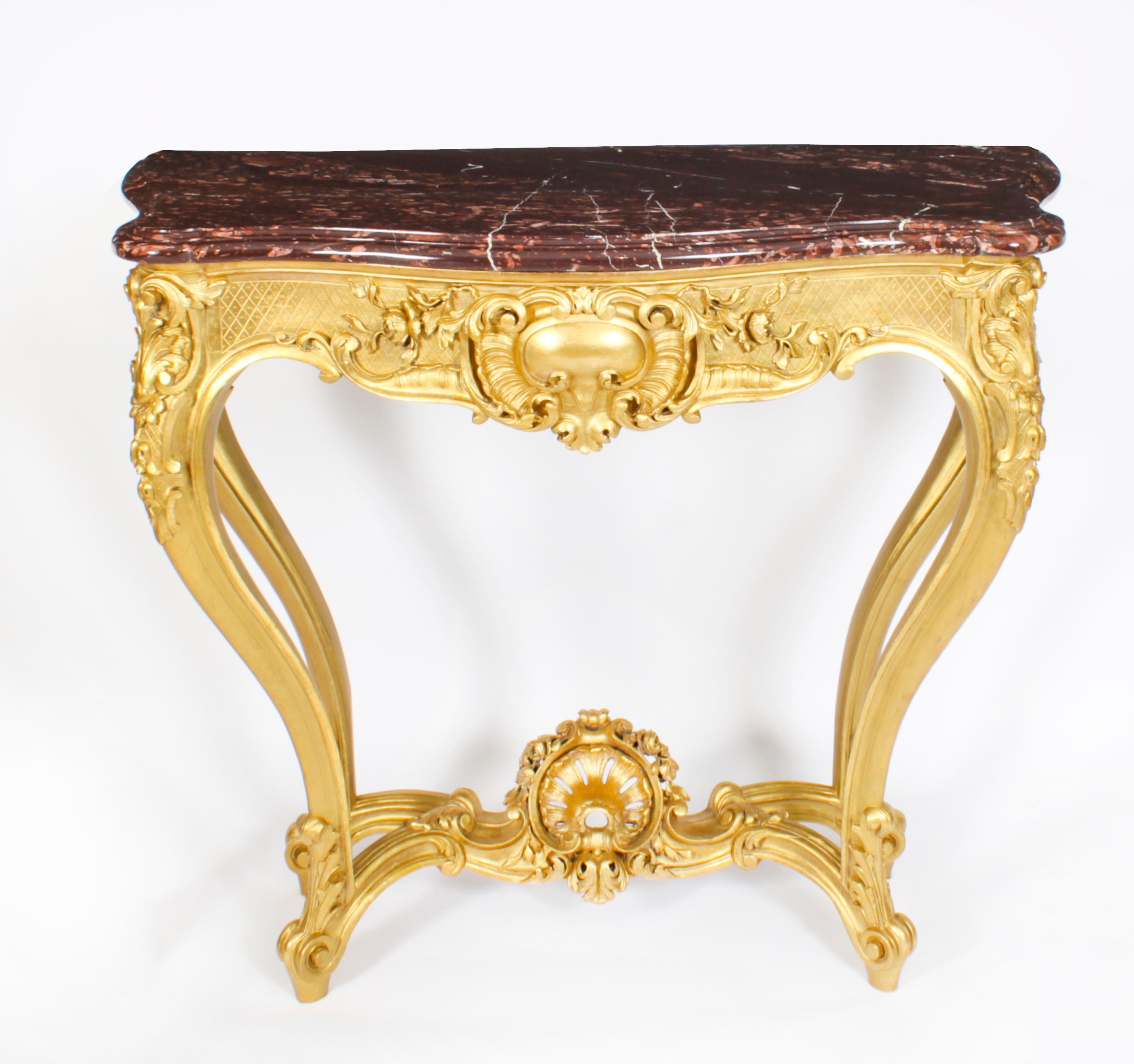 A fine antique Louis XV Revival carved giltwood marble topped console table, circa 1830 in date.
 
This finely carved giltwood console table is surmounted with an exquisite shaped rectangular Vielle Brun marble top above a frieze carved with