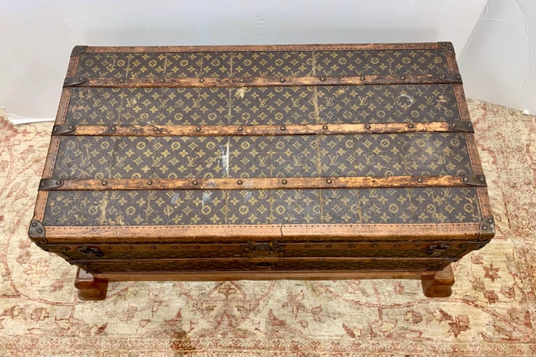 A Louis Vuitton trunk from the 1930’s covered in LV monogram fabric, bound in leather and brass with wood banding. Interior is lined with original fabric and two tags, “Marshall Fields” and “Louis Vuitton, 149 New Bond Street, London”. The brass