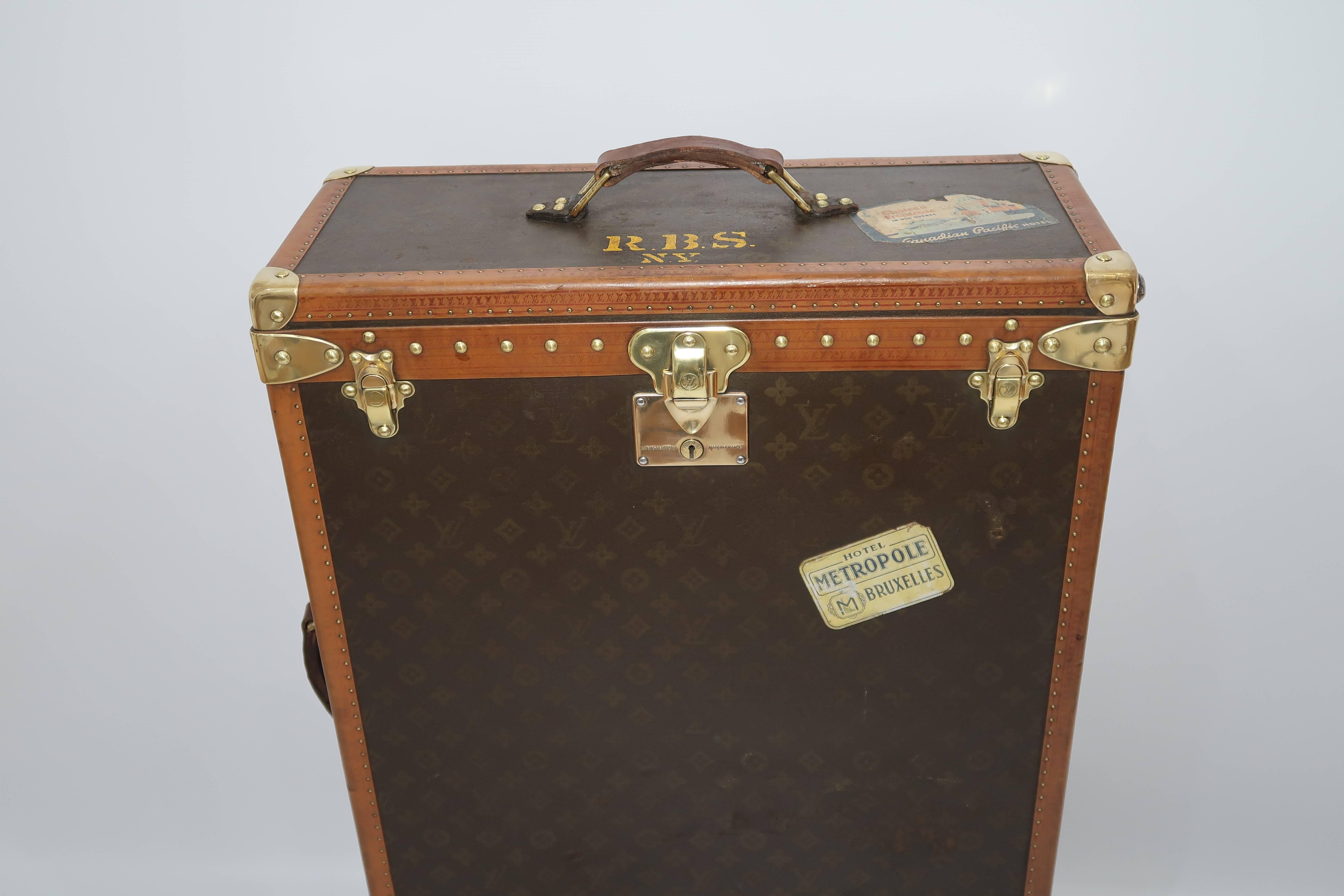 For sale an antique Louis Vuitton Monogram wardrobe trunk, finished in Monogram canvas with brass hardware, original travel and hotel stickers and LV stamped lozine bounding.

Perfect dimensions so that it can be used as TV stand or side table.