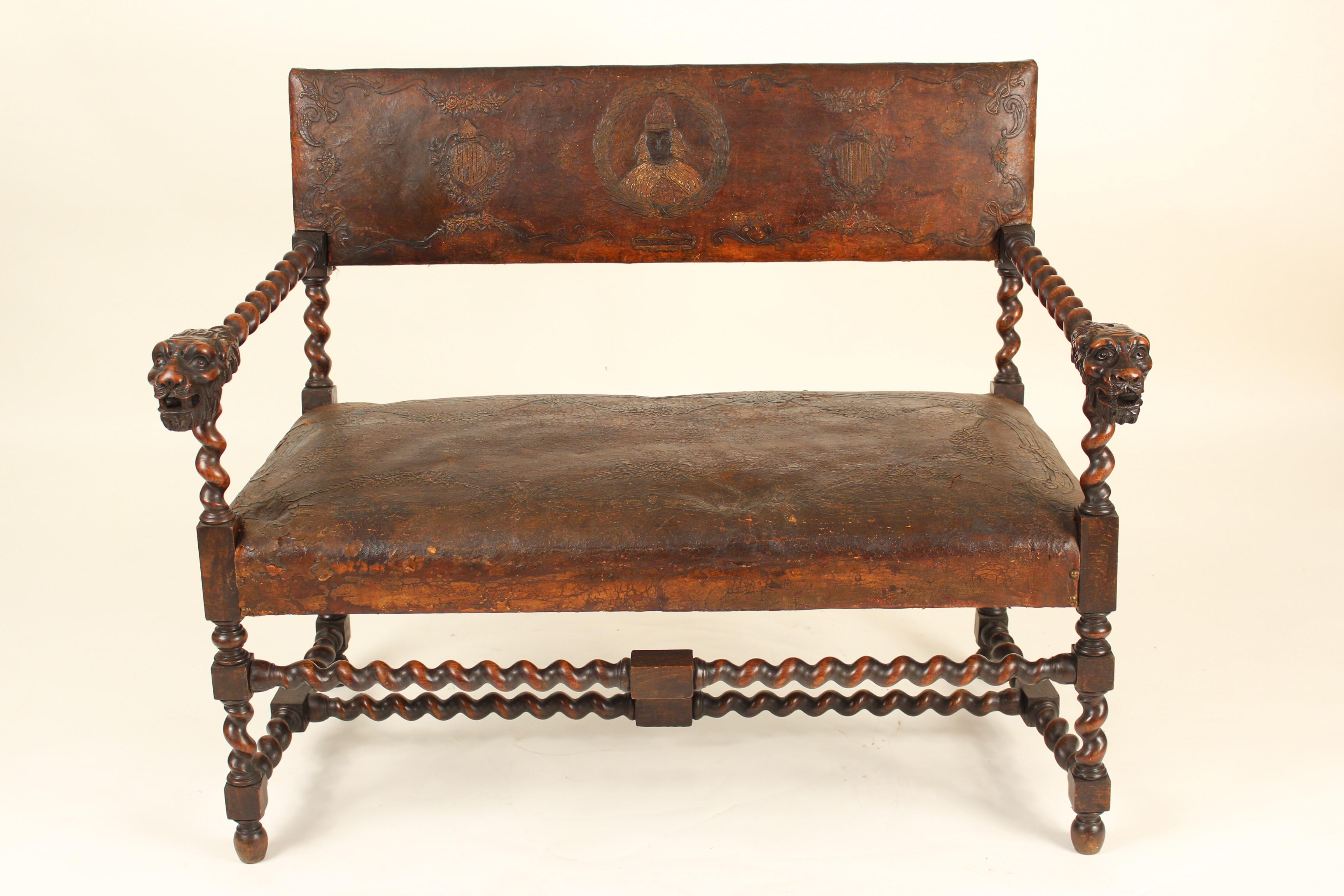 Louis XIII style carved beech wood settee, circa 1890-1910. This settee has original embossed leather upholstery, great lion carved arms, turned legs and stretcher bars.