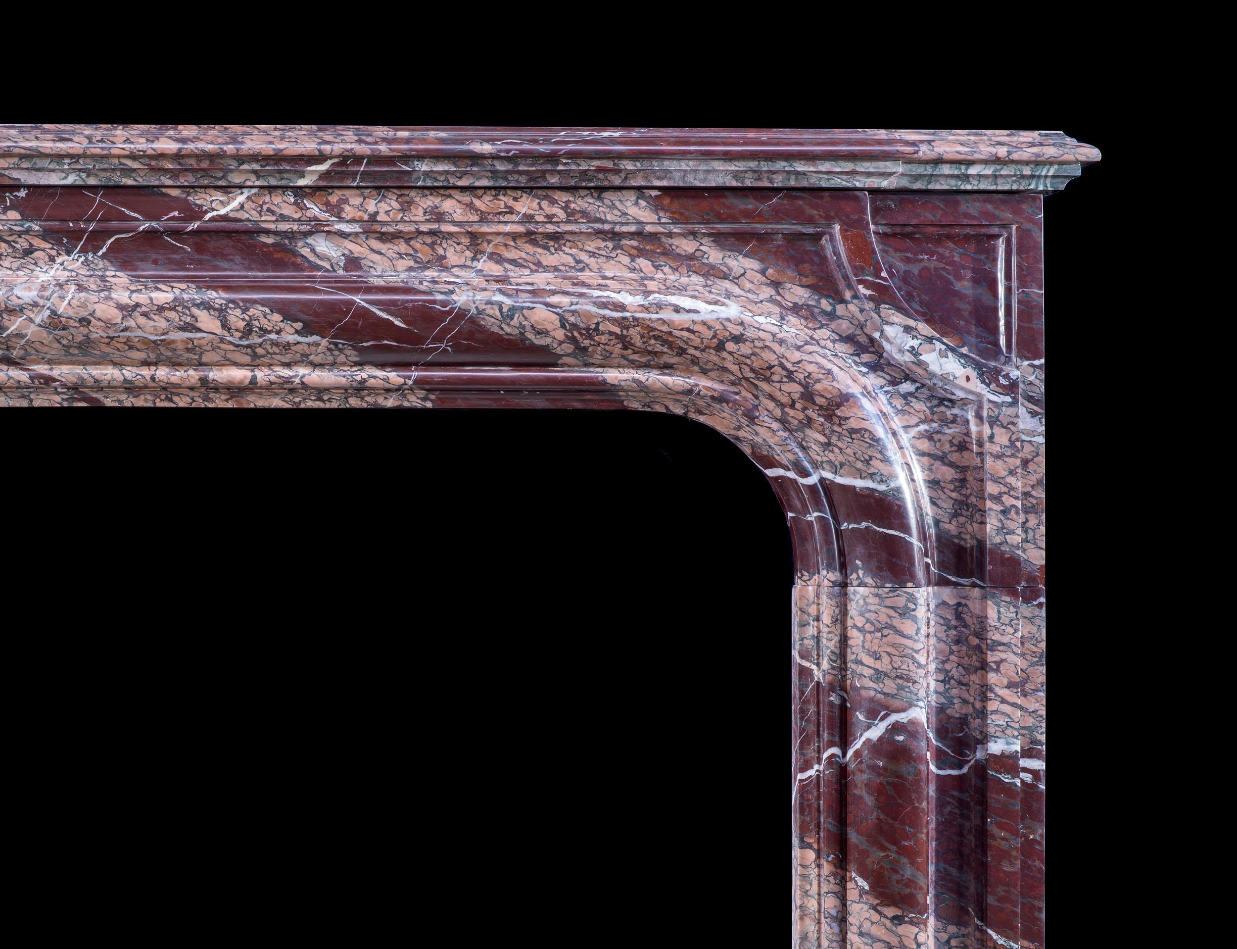 Cheminée ancienne de Louis XIV en marbre Campan à rubans, d'une beauté exceptionnelle et richement veiné. L'ouverture à bolection généreusement moulée avec des coins arrondis est placée dans un cadre moulé simple avec des coins concaves, le tout