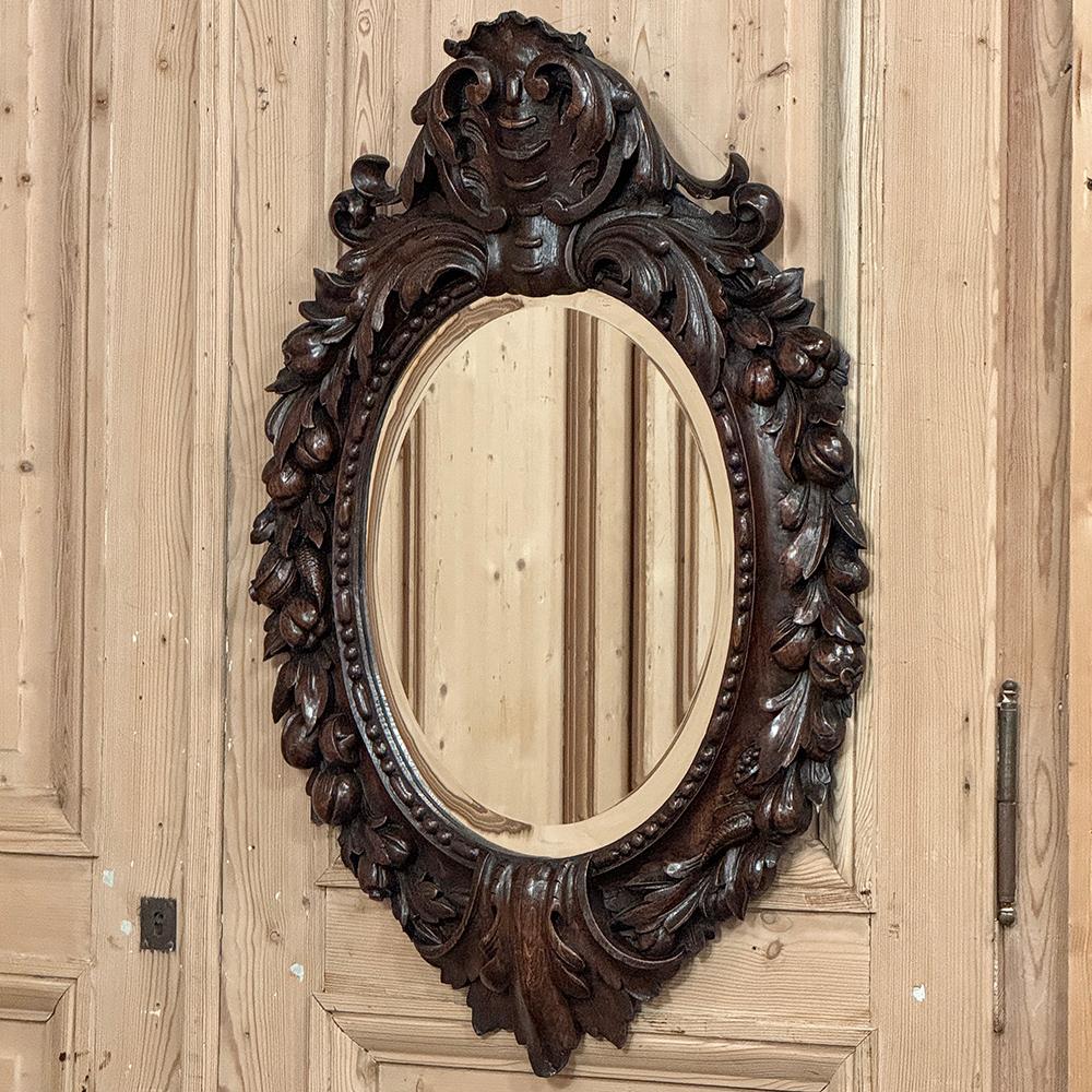 Le miroir mural en bois sculpté Arte Antiques est une magnifique représentation de l'art du sculpteur sur bois !  Une crête audacieuse et complexe surplombe le cadre ovale, contrebalancée par un motif stylisé de fleur de lys inversée à la base. 