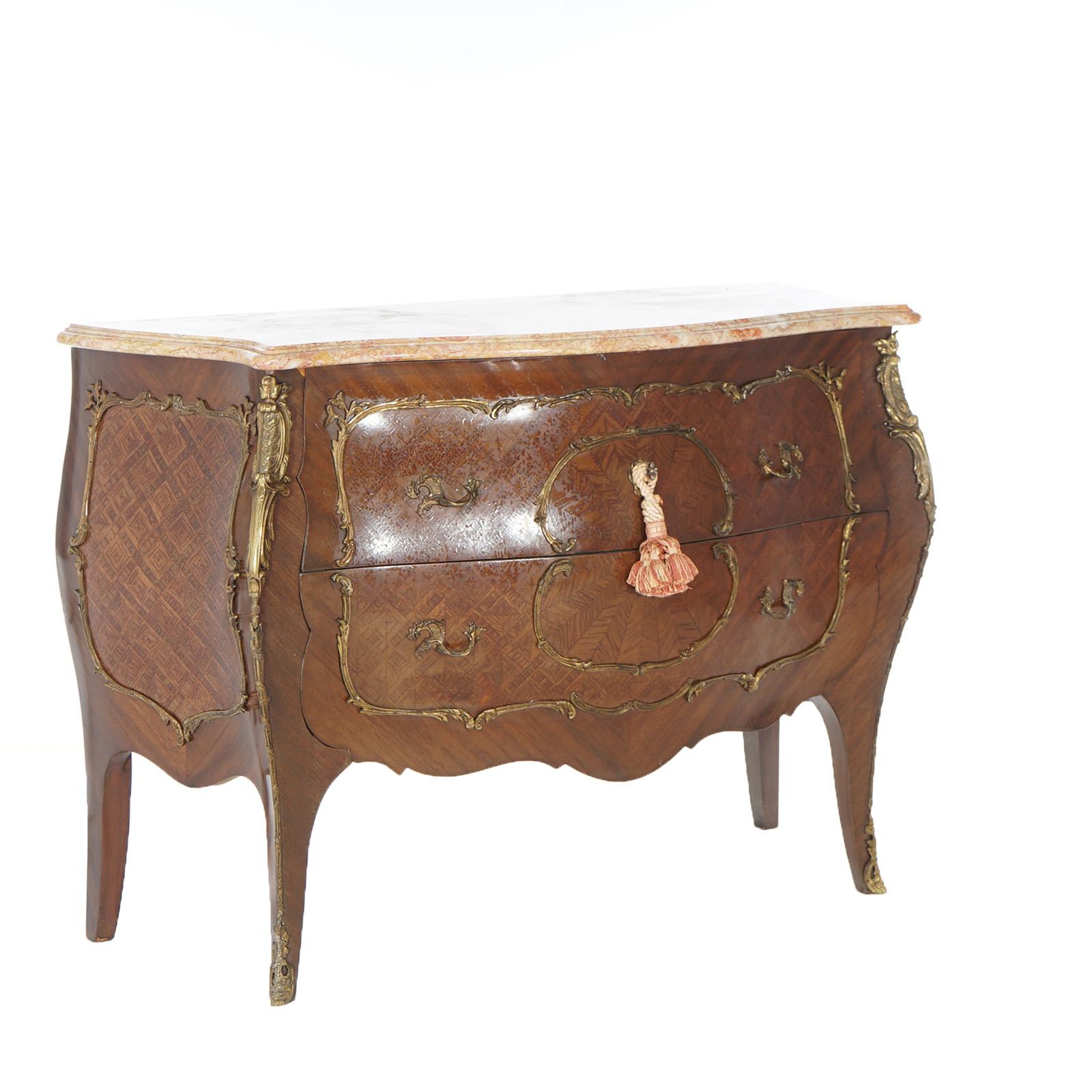 An antique French Louis XIV style commode offers shaped and beveled marble top over bombe chest having allover kingwood and satinwood parquetry inly, cast foliate  ormolu mounts, two deep drawers and raised on cabriole legs, c1920

Measures-