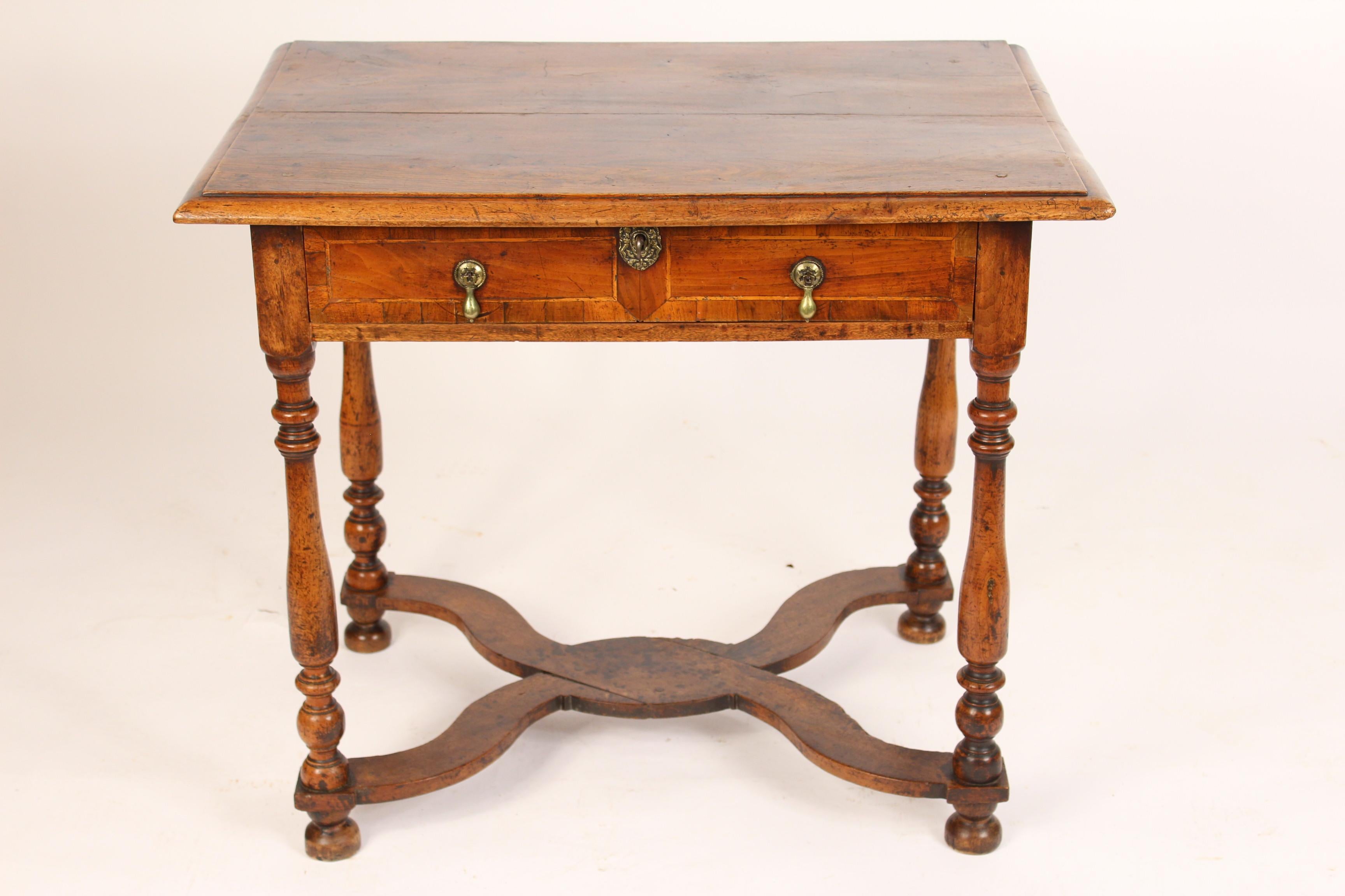 Antique Louis XIV style walnut occasional table, 19th century. With a partial grain painted top and X shaped stretcher bar. This table has an excellent old patina.