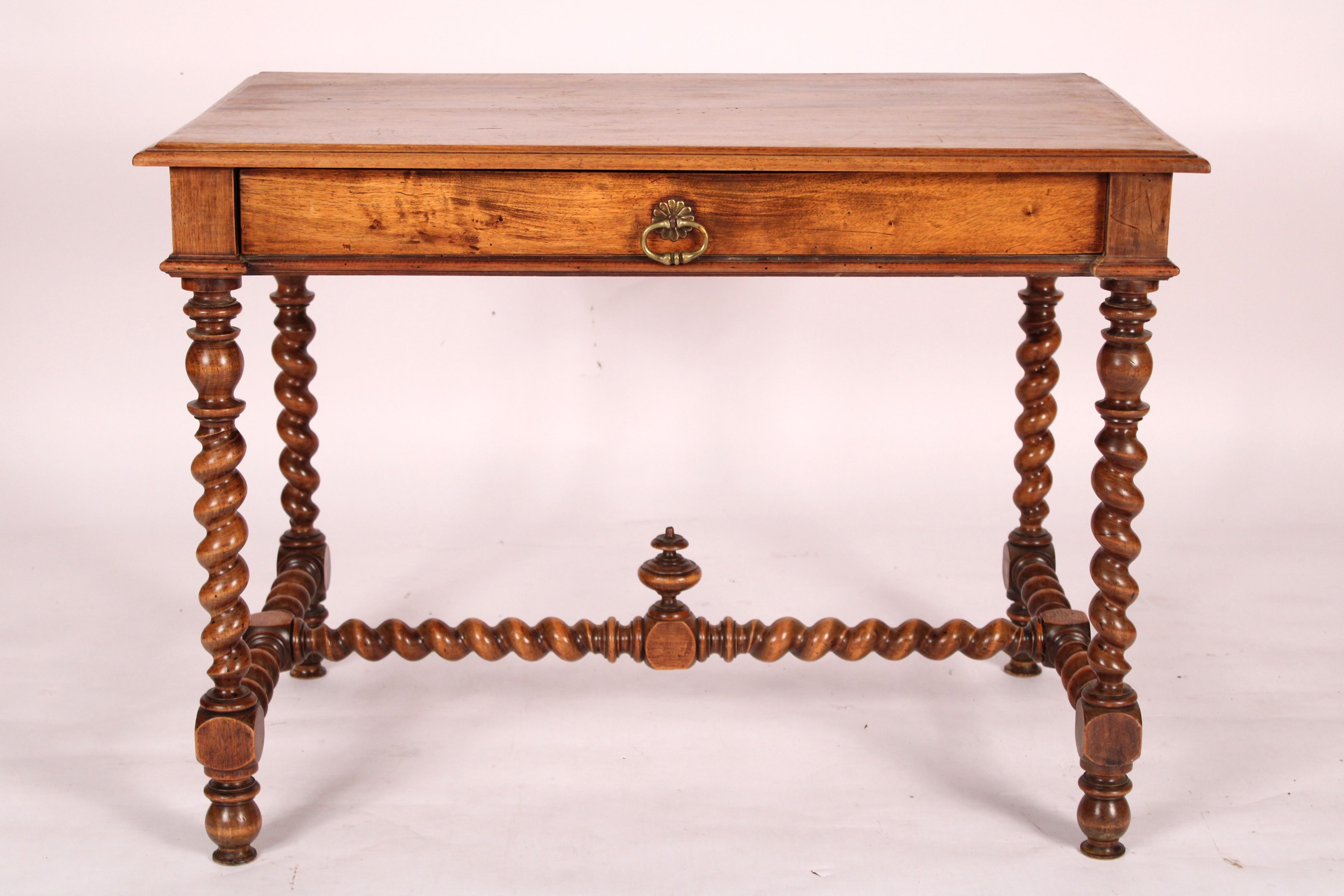 Antique Louis XIV style walnut writing table, circa 1910. With a 3 board top with thumb molded front, side and back edges, a large frieze drawer with brass drawer pull, 4 barley twist legs joined by barley twist stretcher bars, Nice walnut color.