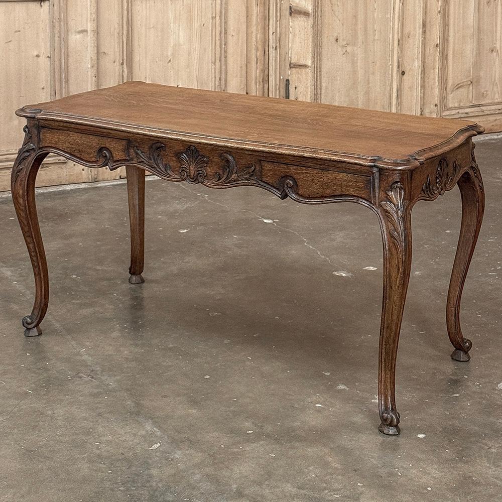 Antique Louis XV Country French Oak Coffee Table features the graceful lines of the style, including an undulating apron supporting a finely contoured and beveled top, all supported by elegant cabriole legs.  Carved detail includes shell and foliate