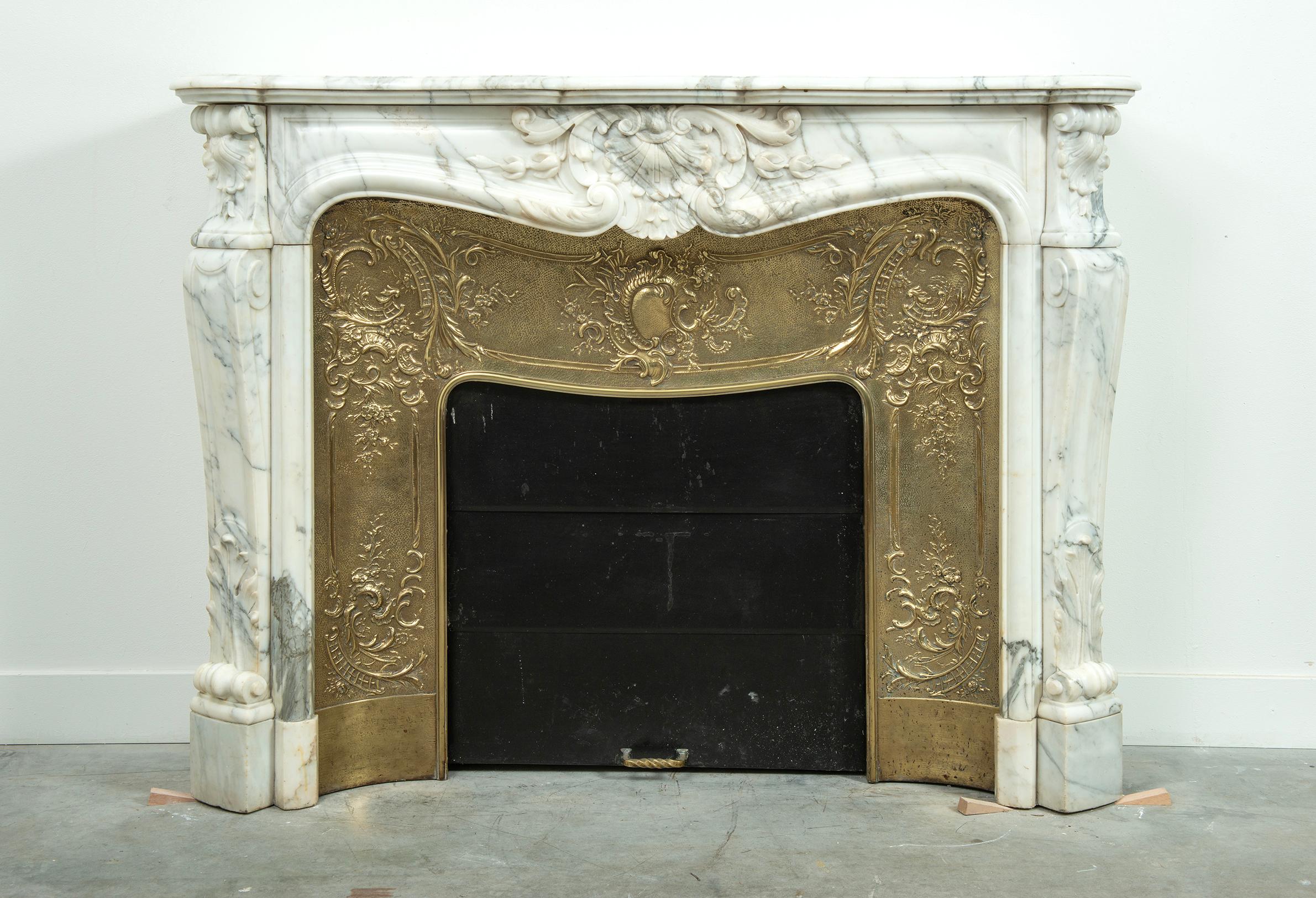 Elevate your space with our exquisite 19th-century White Marble Arabescato Louis XV Fireplace featuring an Antique Louis XV Copper Insert, a masterpiece of timeless elegance and historical allure. 
This exquisite fireplace combines the classic
