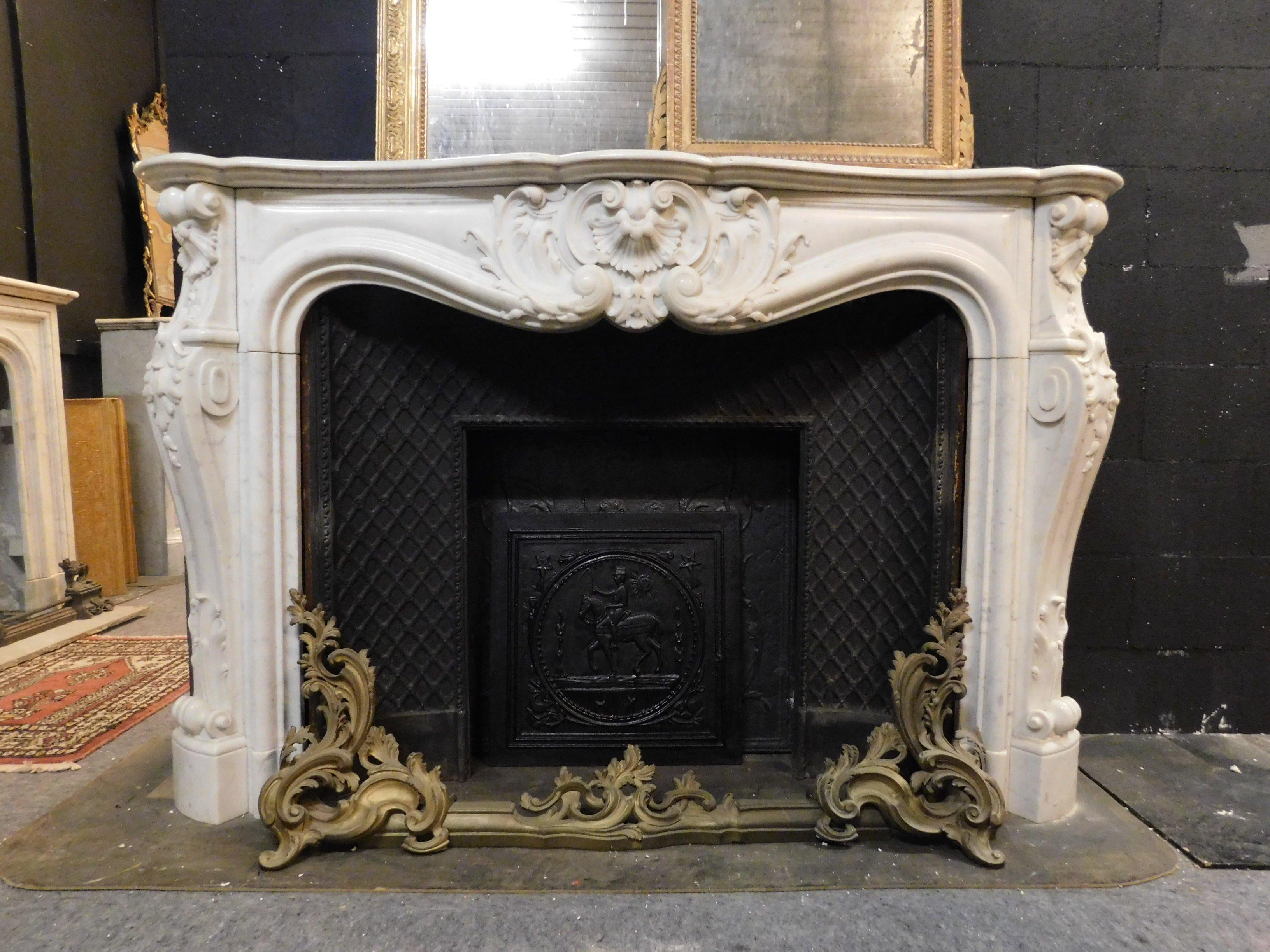 Ancient fireplace in white Carrara marble, Louis XV, richly carved both on the pediment and on the legs that are moved, still enriched by the brass-plated air vents that have on the sides, of great value and refinement, was placed in a reception