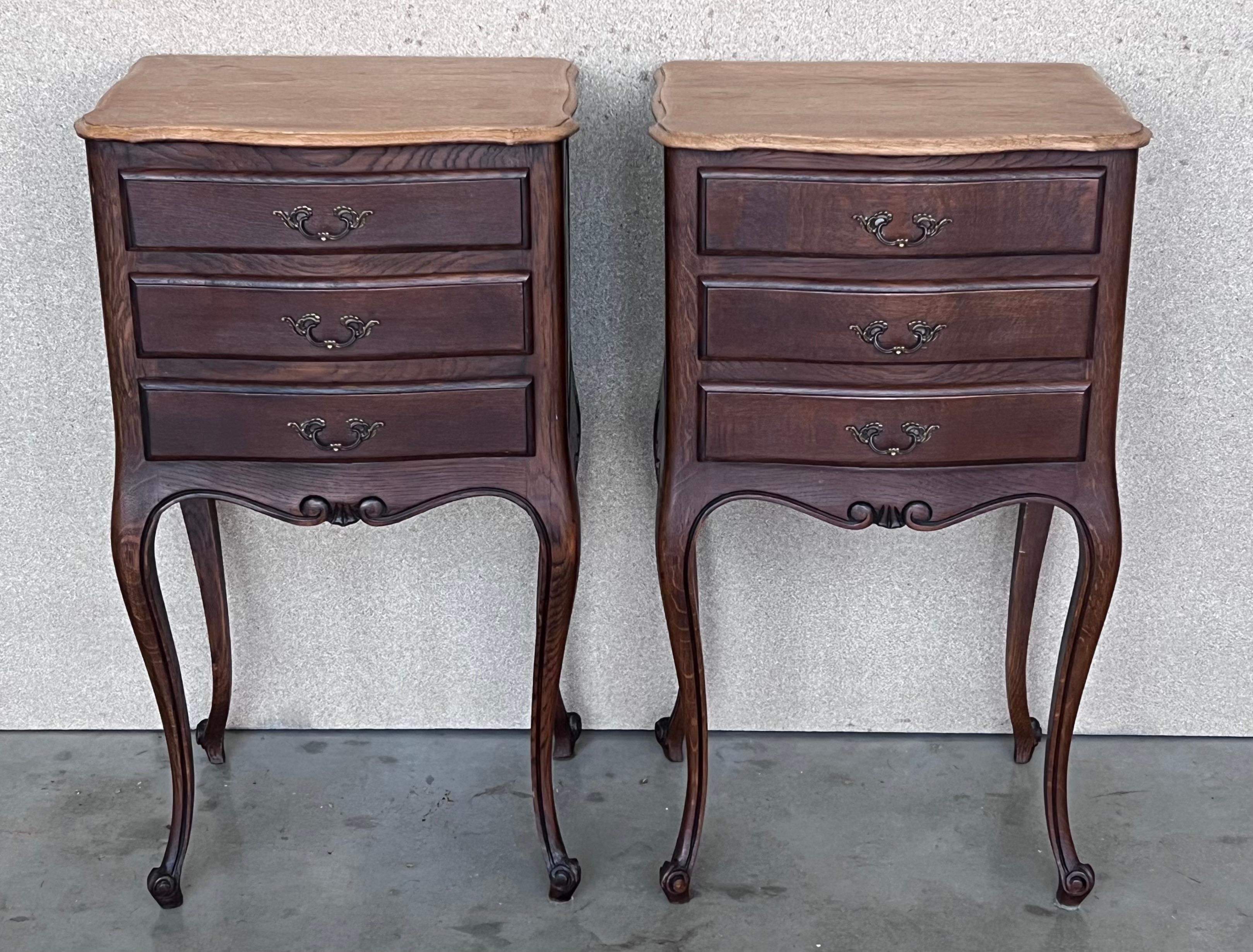 A pair of Antique French Louis XV Marquetry light oak top nightstands. Subtle contours and scroll shapes are evident in the corner posts and legs, which support serpentine sides and an arched front façade for a curvaceous effect. T Veneers with