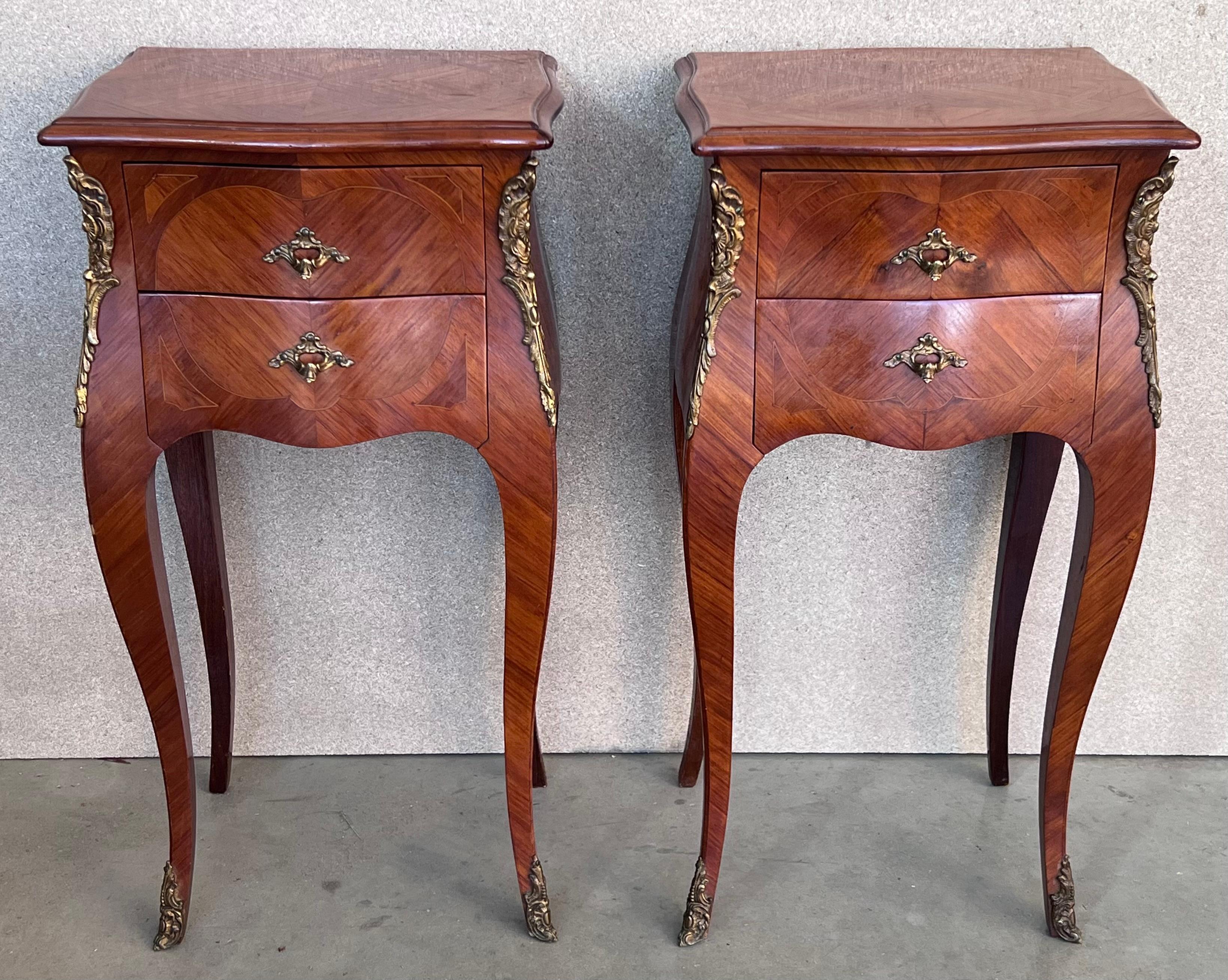 A pair of Antique French Louis XV Marquetry marble top nightstands. Subtle contours and scroll shapes are evident in the corner posts and legs, which support serpentine sides and an arched front façade for a curvaceous effect. The tops are luxurious